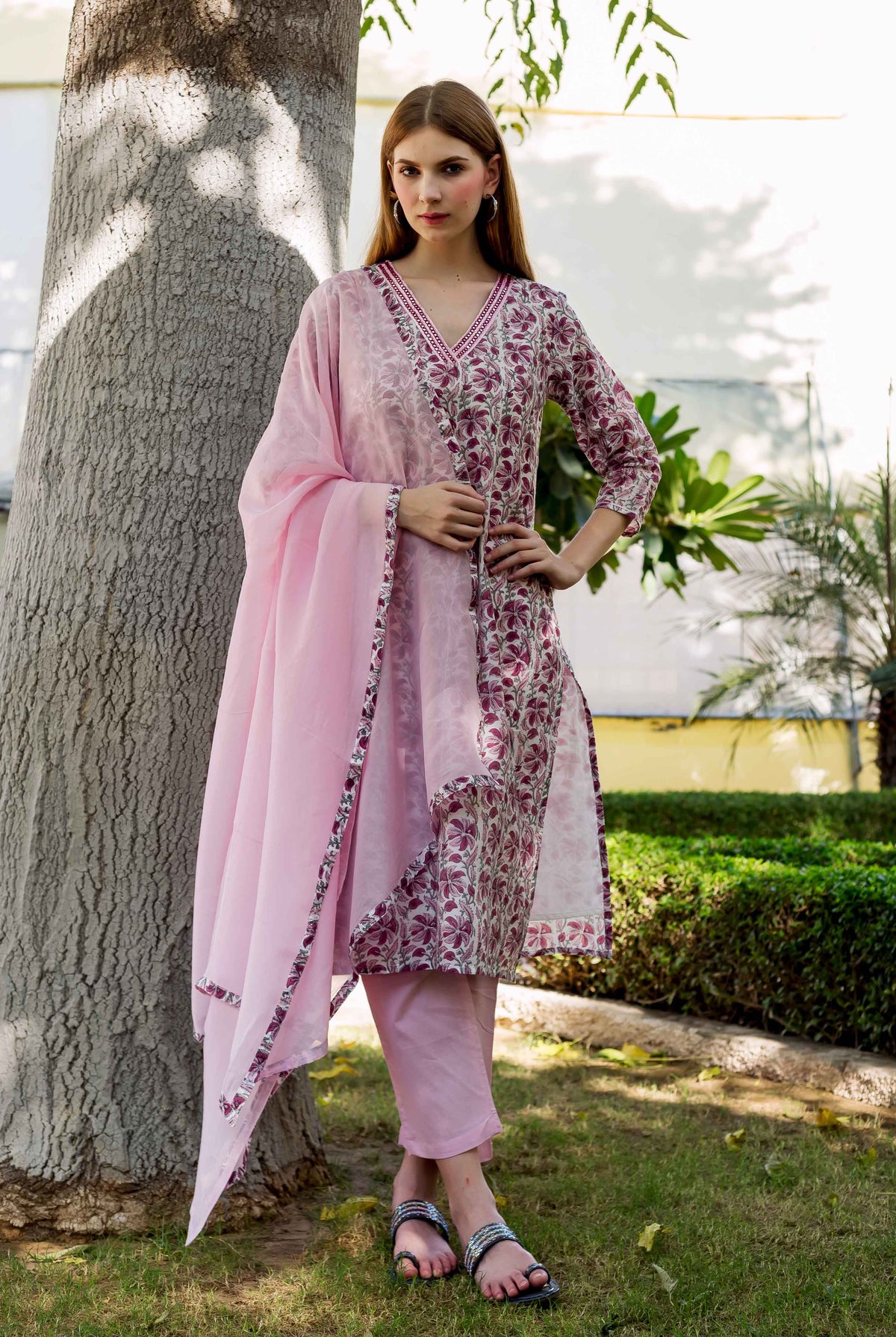 Model wearing a pink ethnic hand-block-printed kurta set with matching pants and dupatta.
