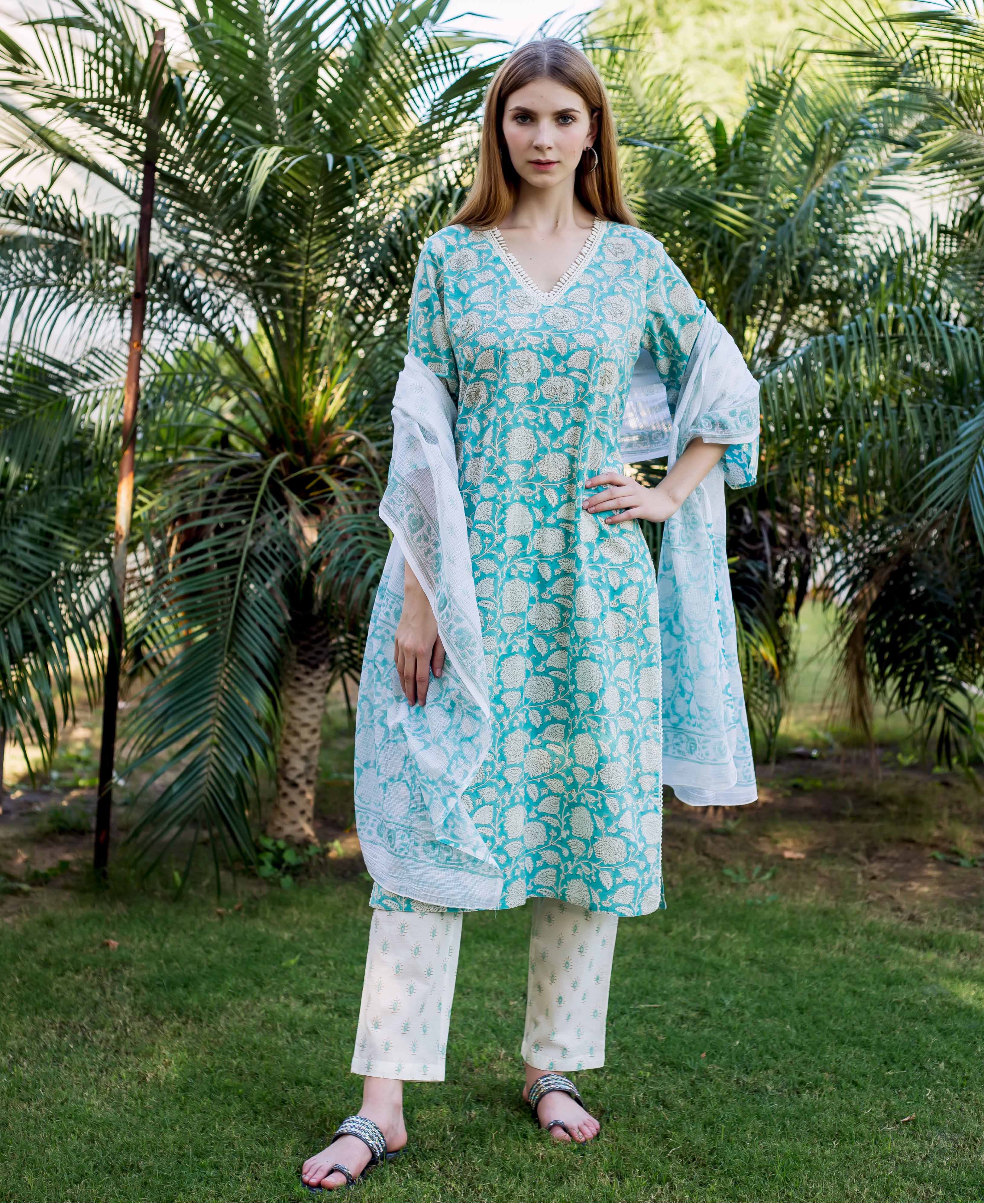 Teal kurta with white floral print and embroidery on a model standing outdoors.