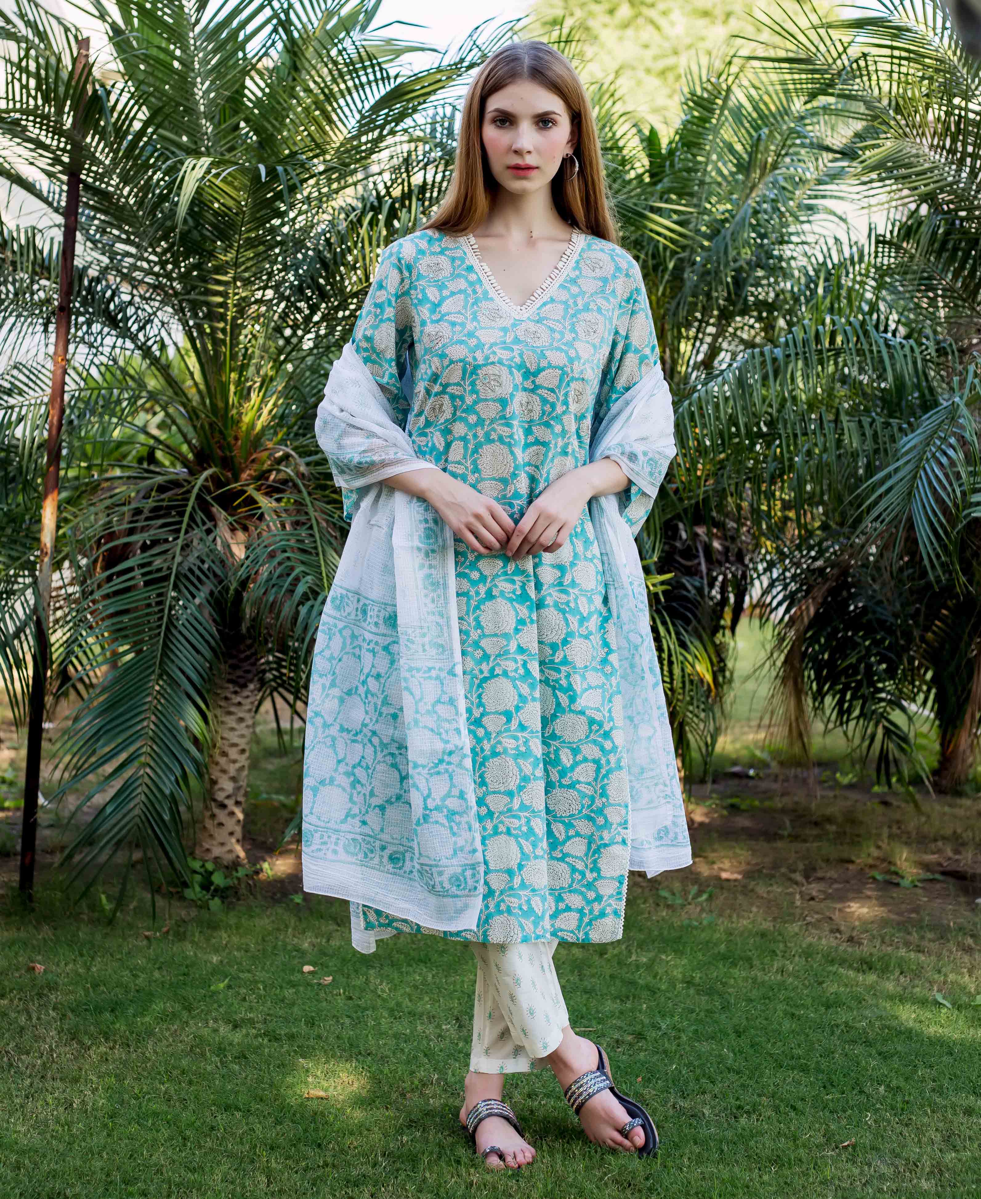 Full-length of woman in teal floral hand-block printed kurta, white pants, and dupatta.