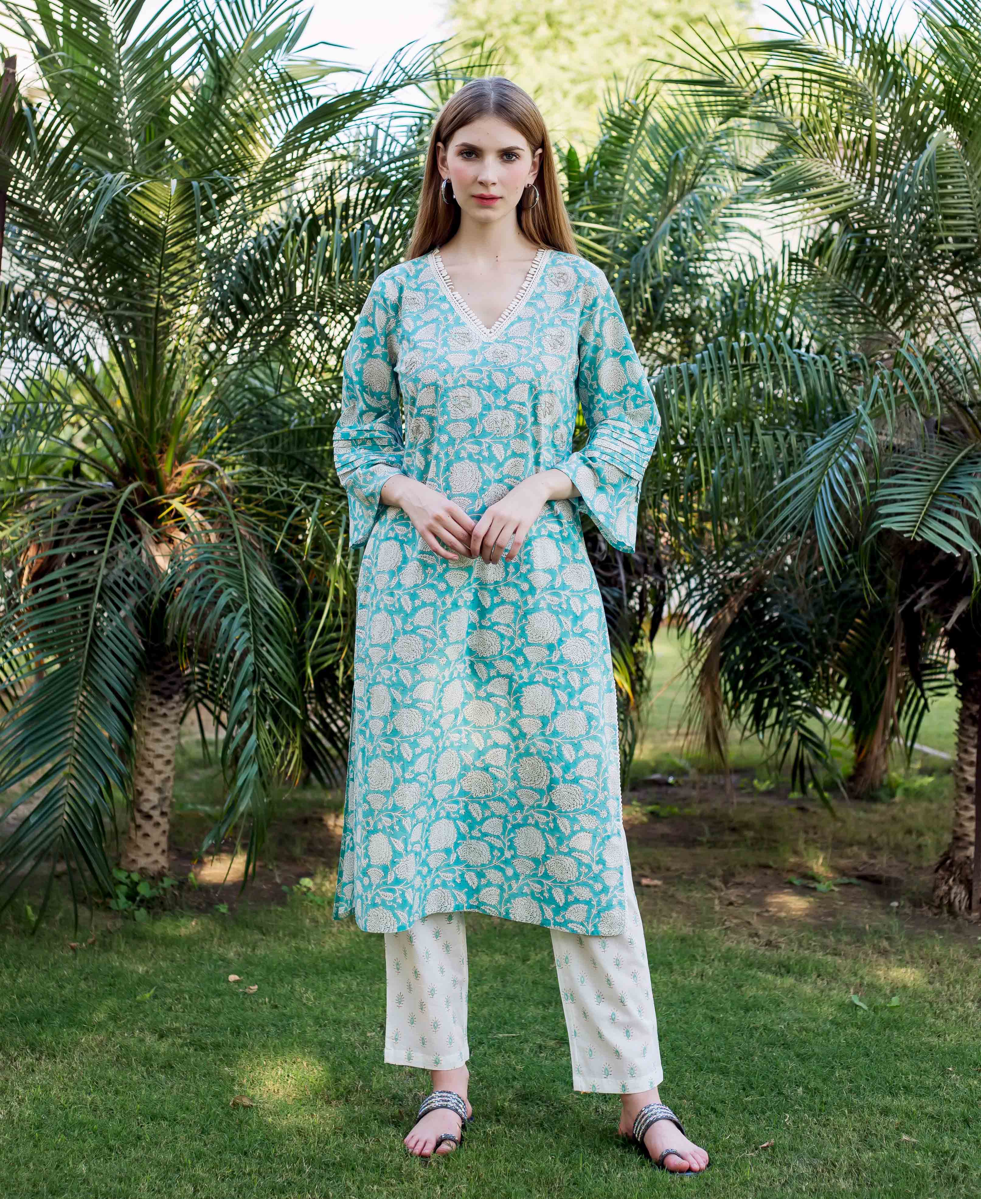Woman wearing teal and white embroidered and hand-block-printed ethnic kurta with floral patterns.