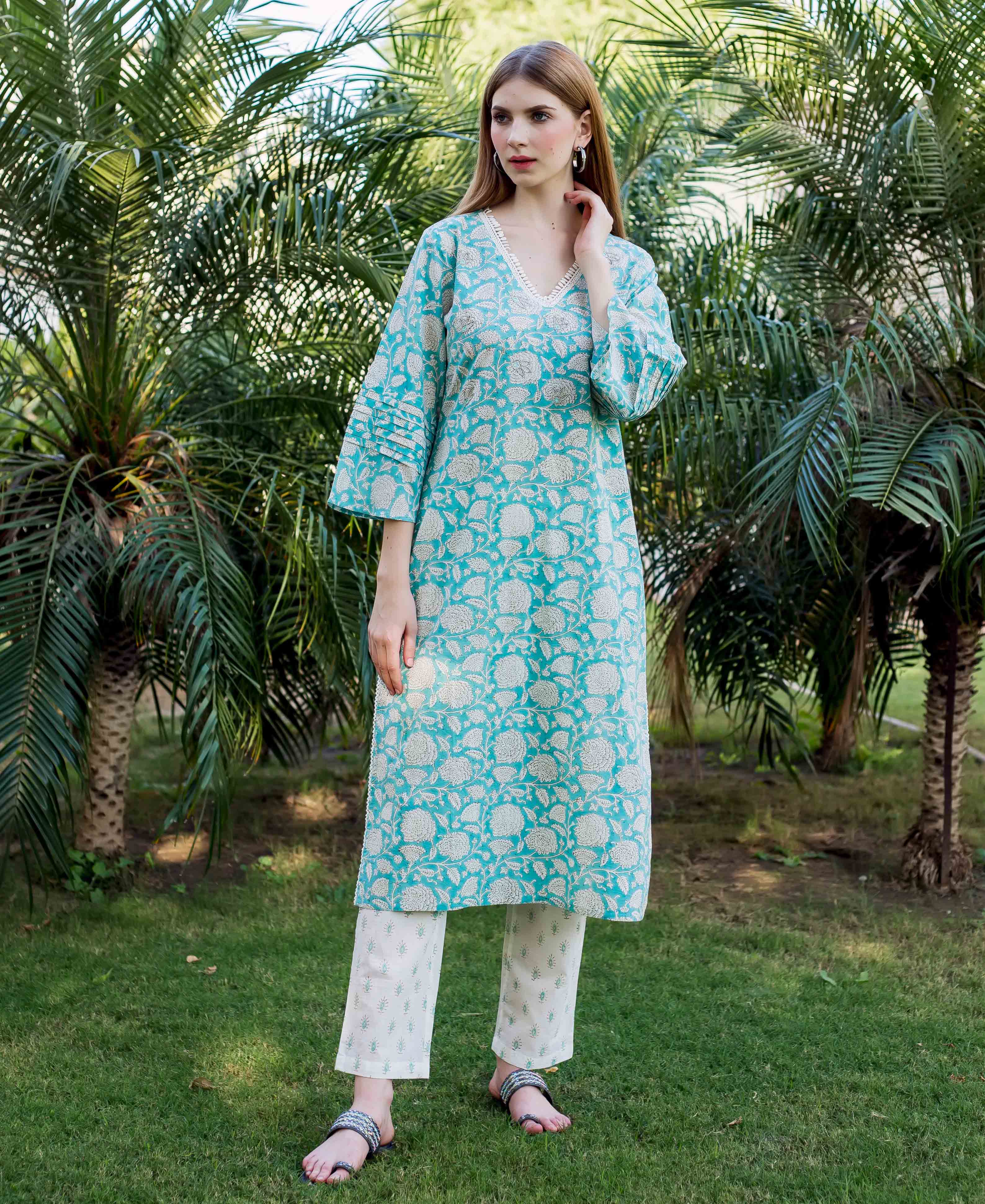 Full-length model in a teal hand-block-printed floral kurta with embroidered V-neck and matching pants.