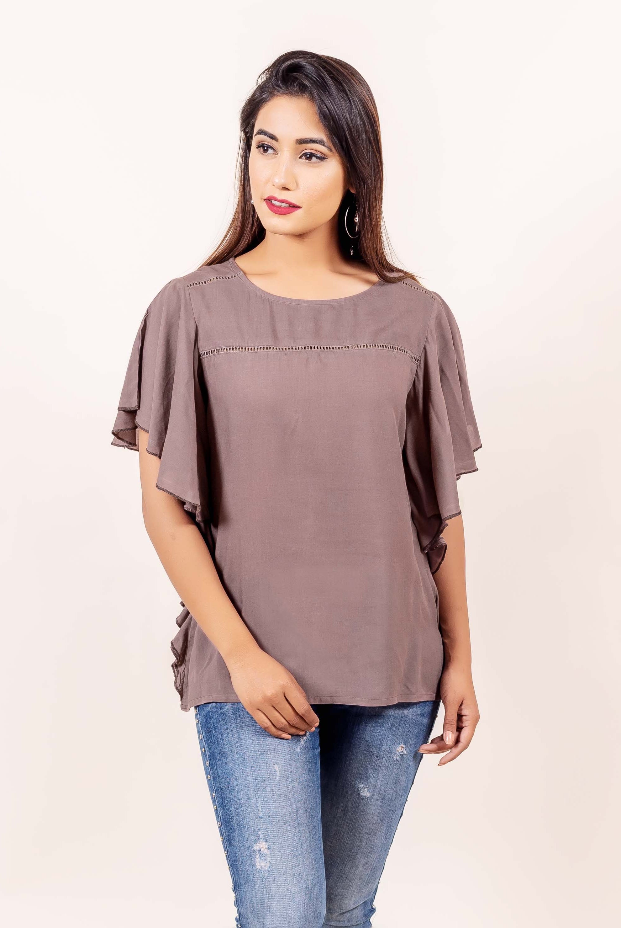 Front view of model wearing brown bell sleeves top with delicate perforated yoke detail.