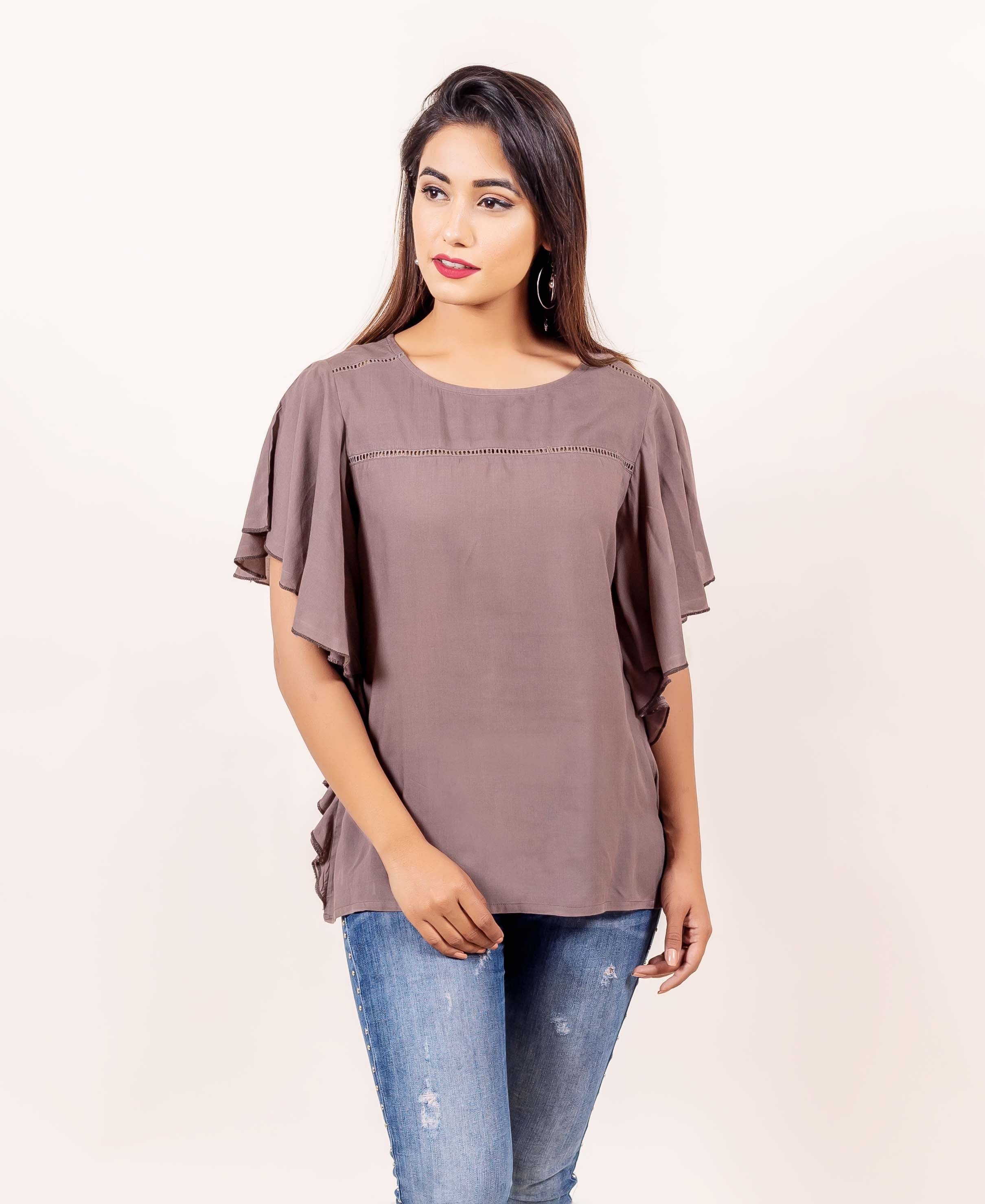 Front view of model wearing brown bell sleeves top with delicate perforated yoke detail.