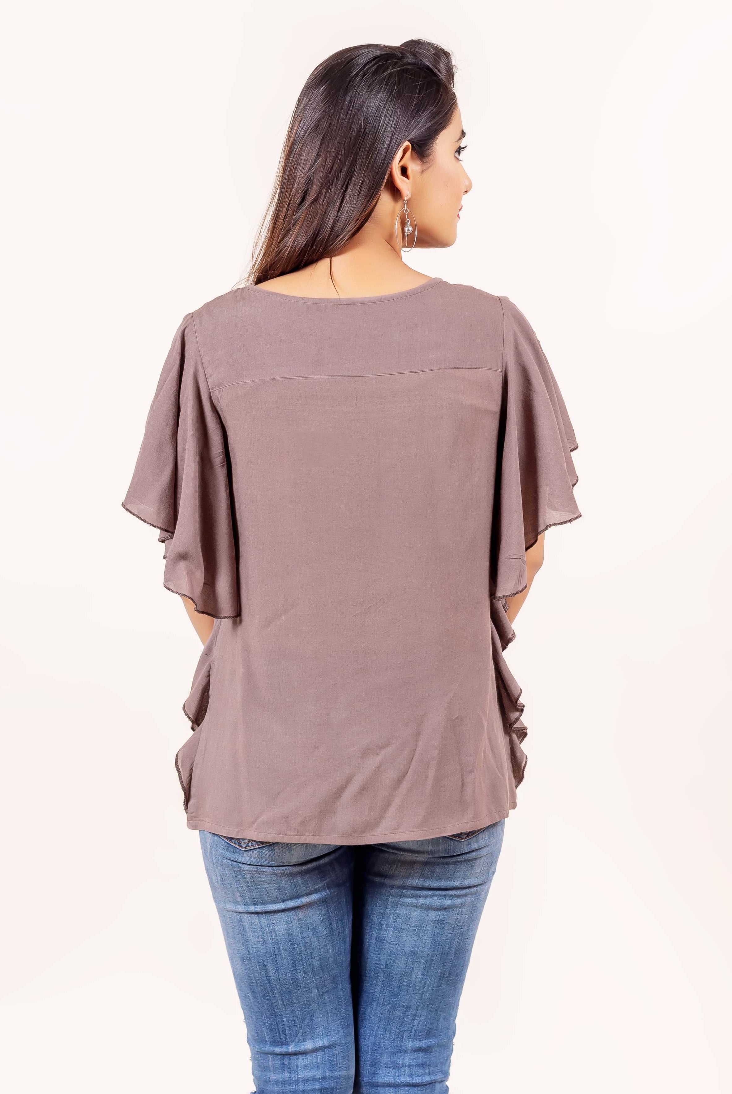Rear view of model wearing a brown bell-sleeved top with ruffle detailing.