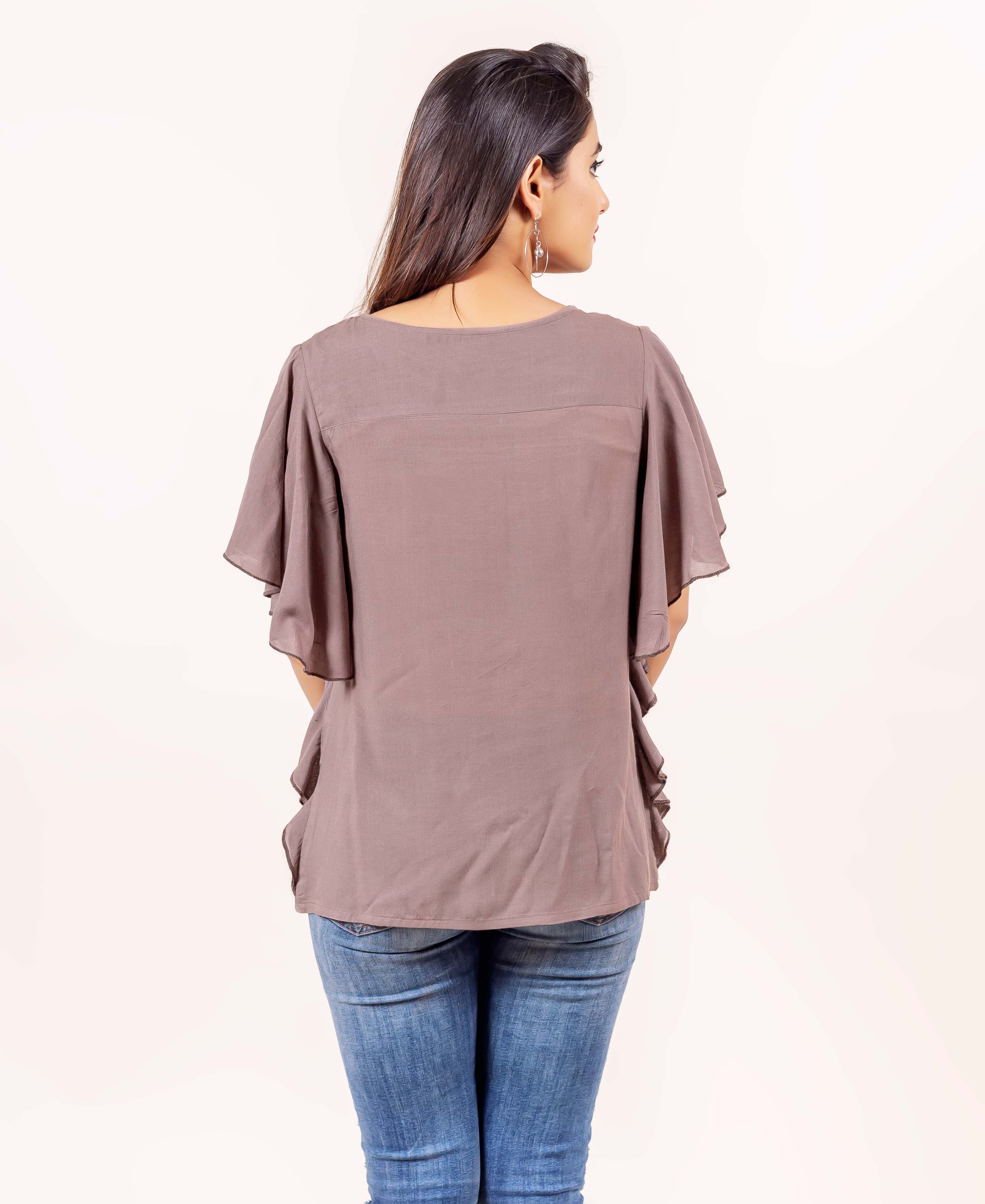 Rear view of model wearing a brown bell-sleeved top with ruffle detailing.