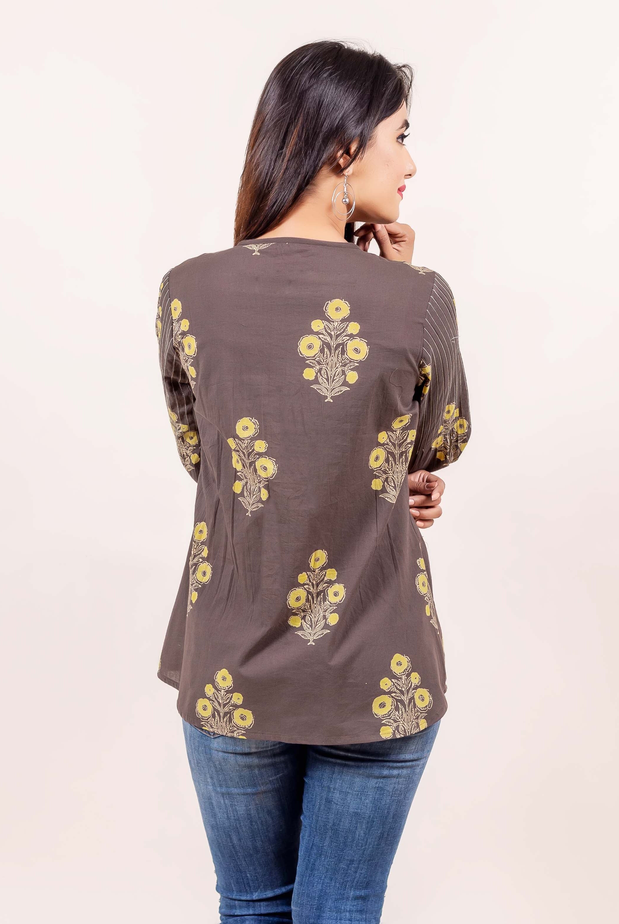 Back view of model wearing a brown hand-block printed top with yellow floral motifs.