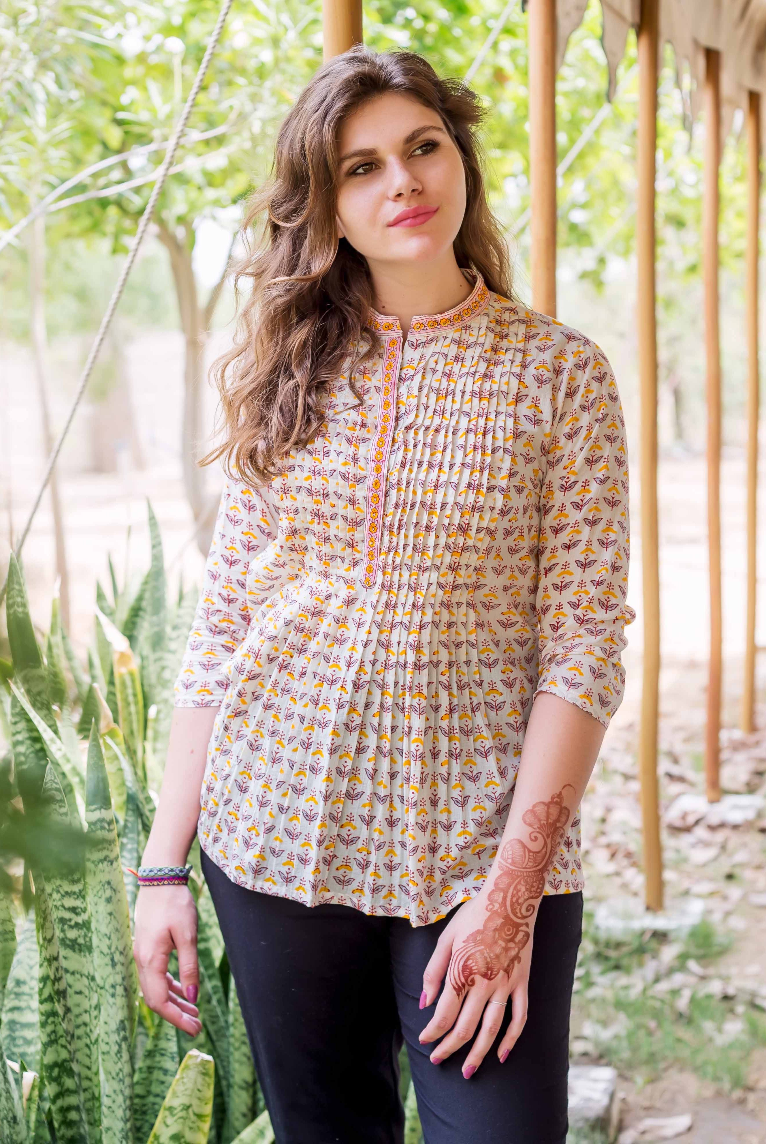 Female model wearing an off-white block-printed pintuck ethnic top with yellow and maroon patterns.