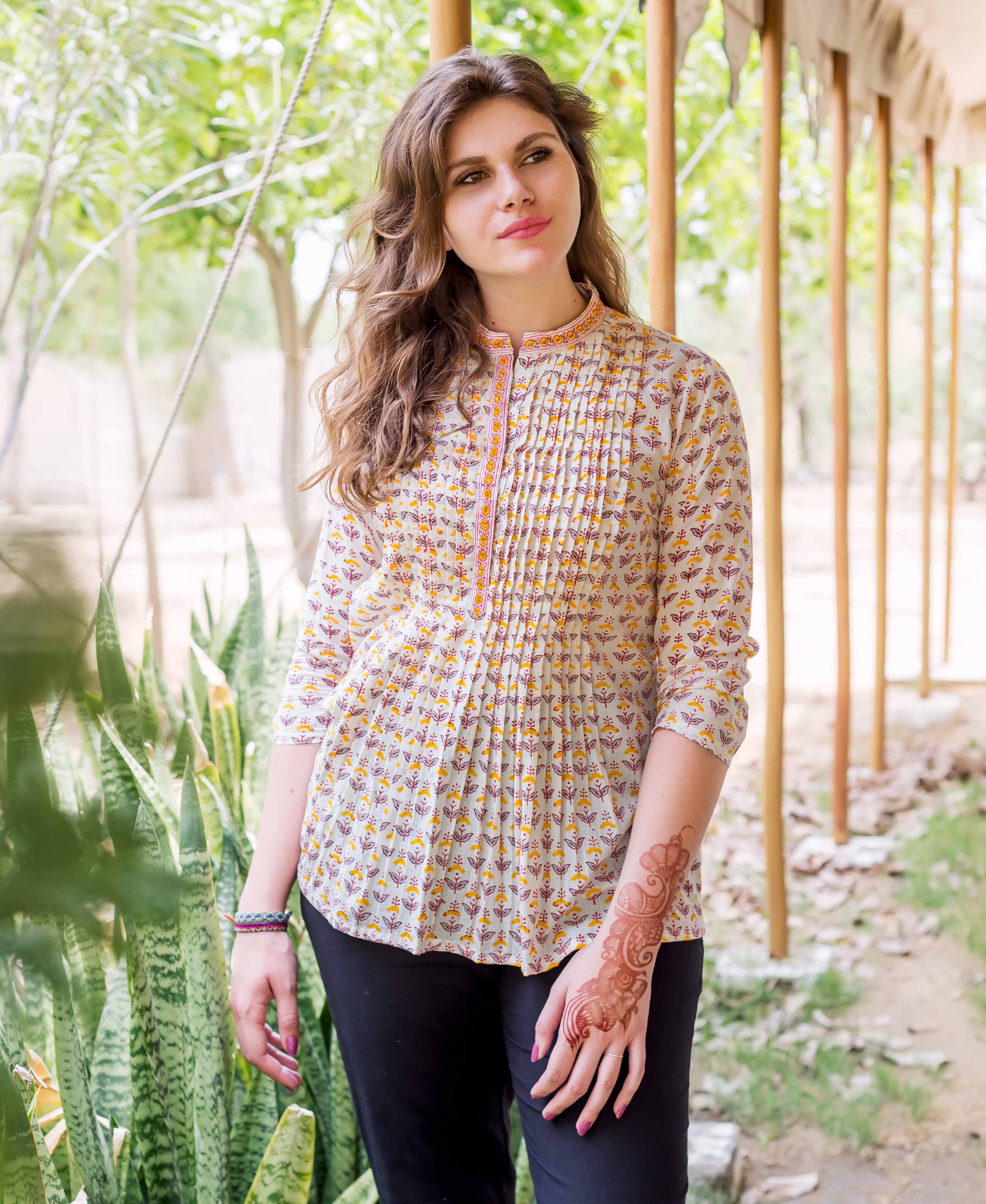 Female model wearing an off-white block-printed pintuck ethnic top with yellow and maroon patterns.