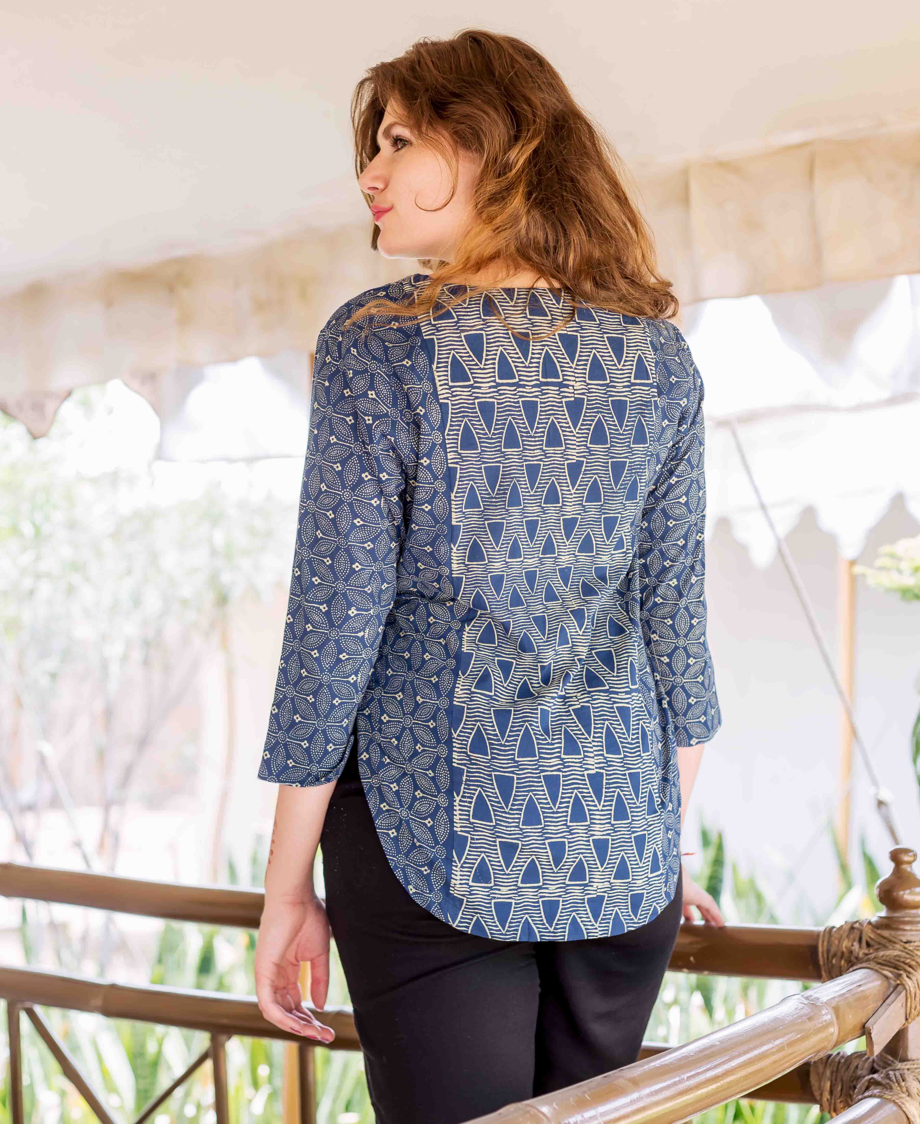 Back view of model in indigo hand-block-printed ethnic top with geometric and floral designs.