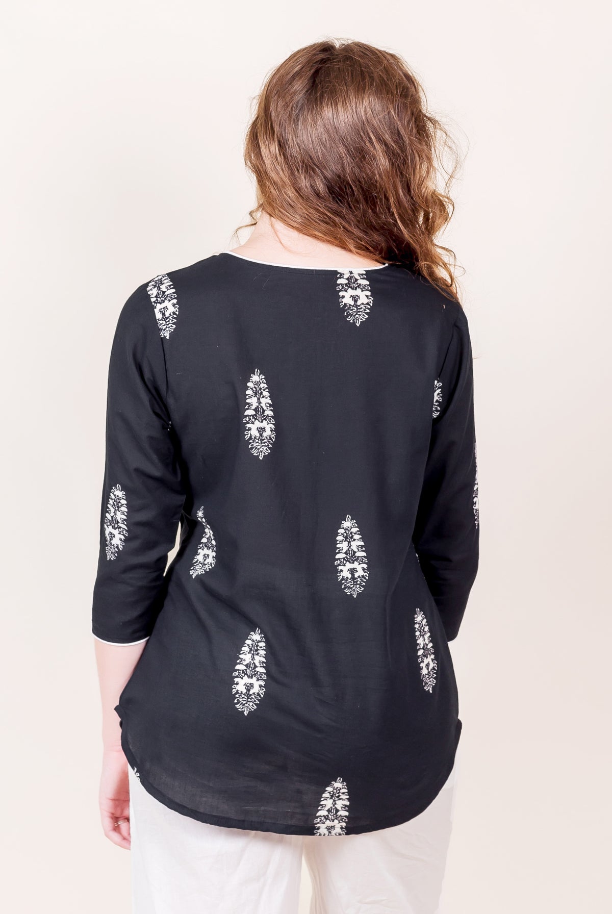 Black cotton top with white paisley print, on model from behind, three-quarter sleeves.