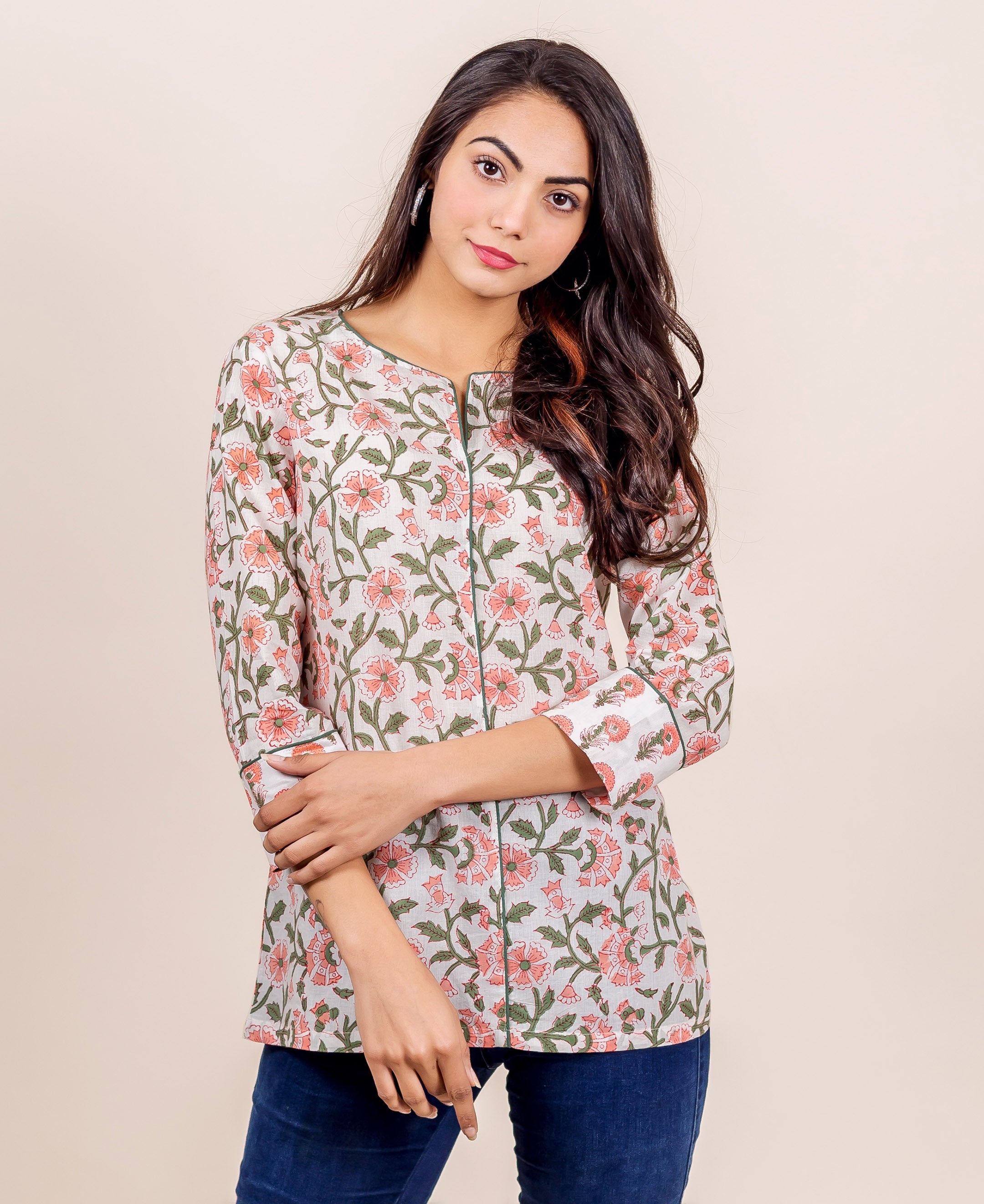 Model wearing a white top with pink floral and green leaf hand block print.