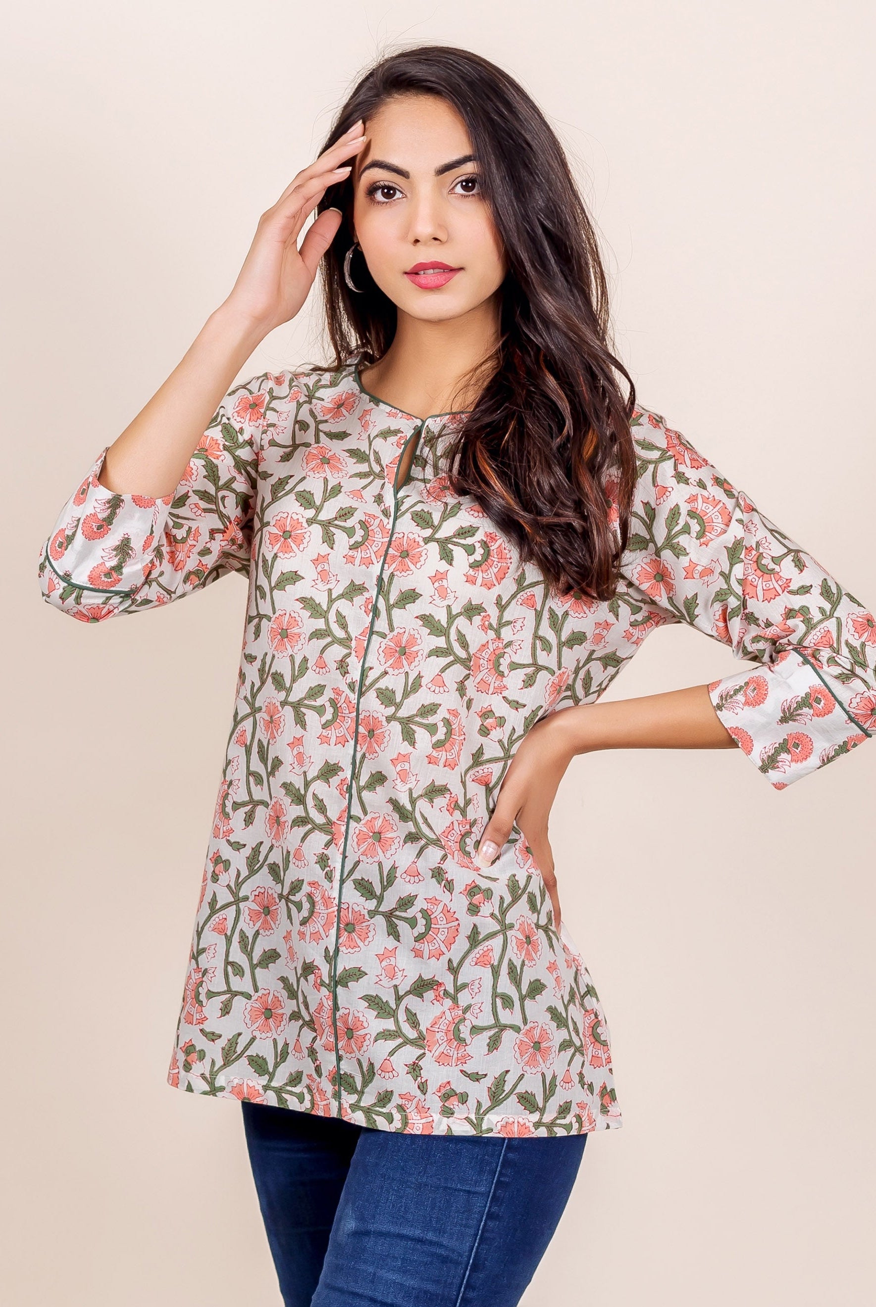 Model posing in a white top with pink floral and green leaf hand block print.