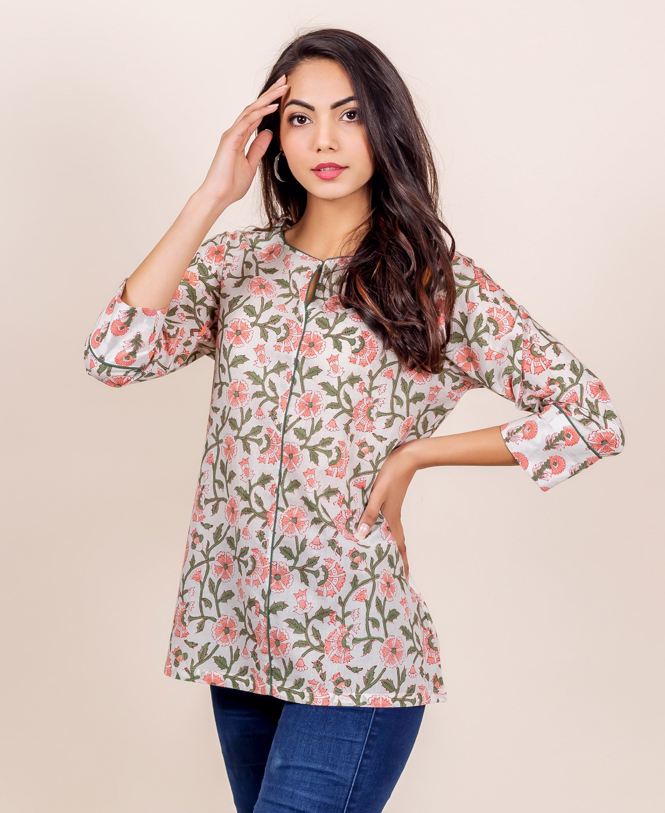 Model posing in a white top with pink floral and green leaf hand block print.