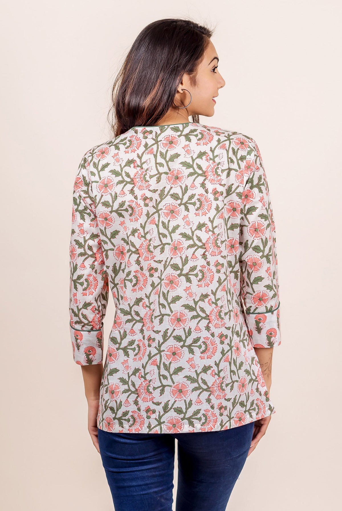 Back view of model in white and pink hand block printed floral top, 3/4 sleeves.
