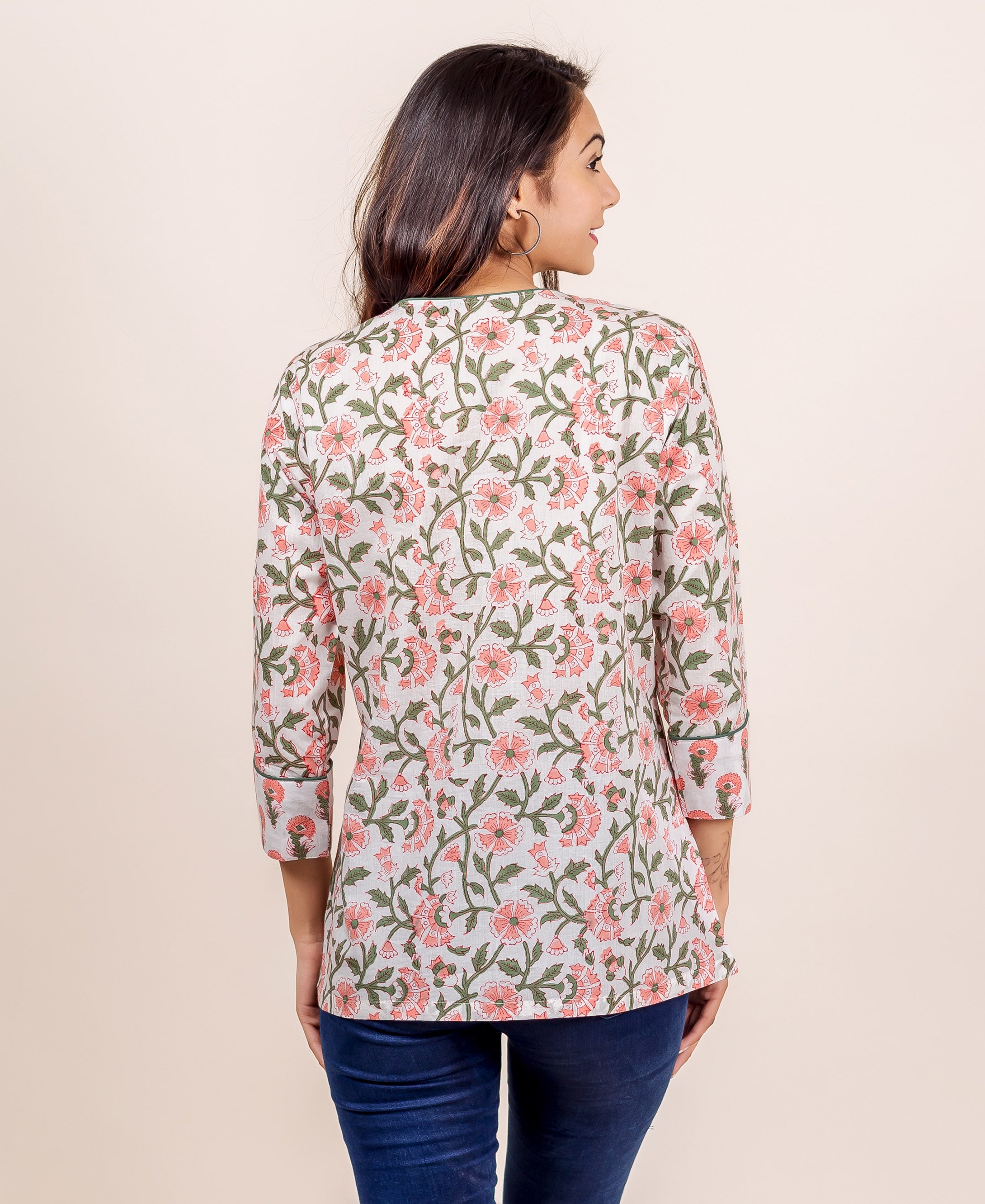Back view of model in white and pink hand block printed floral top, 3/4 sleeves.