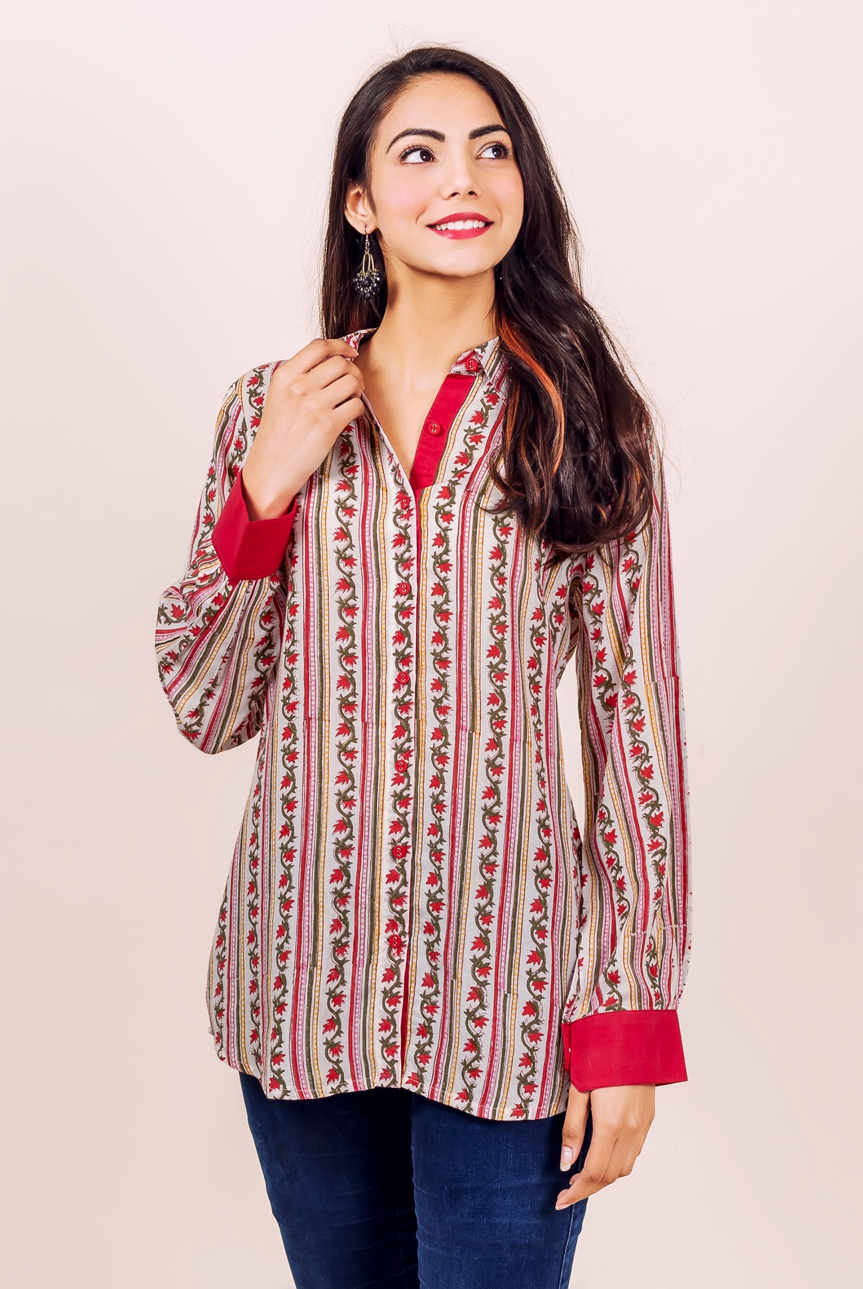 Woman wearing white and red hand block printed striped floral shirt top with red cuffs.