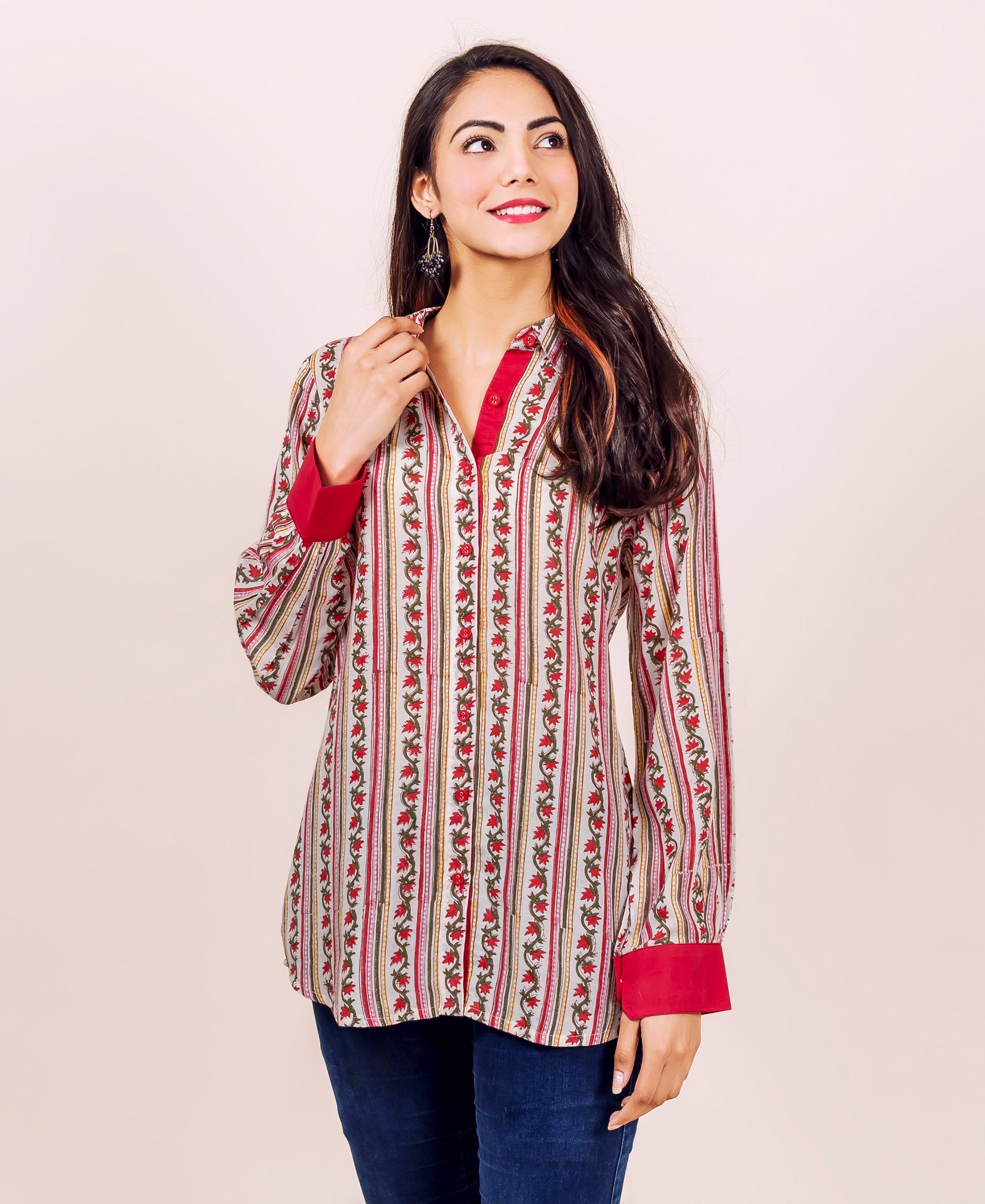 Woman wearing white and red hand block printed striped floral shirt top with red cuffs.
