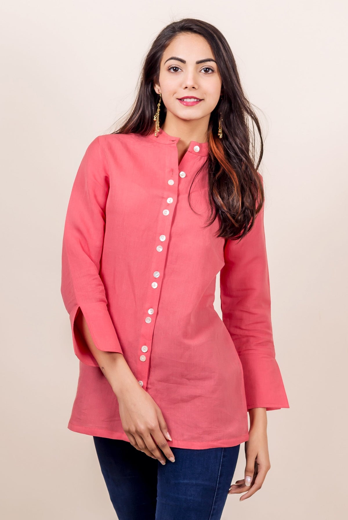 Model wears a peach linen top, buttoned-down, with 3/4 sleeves and band collar.