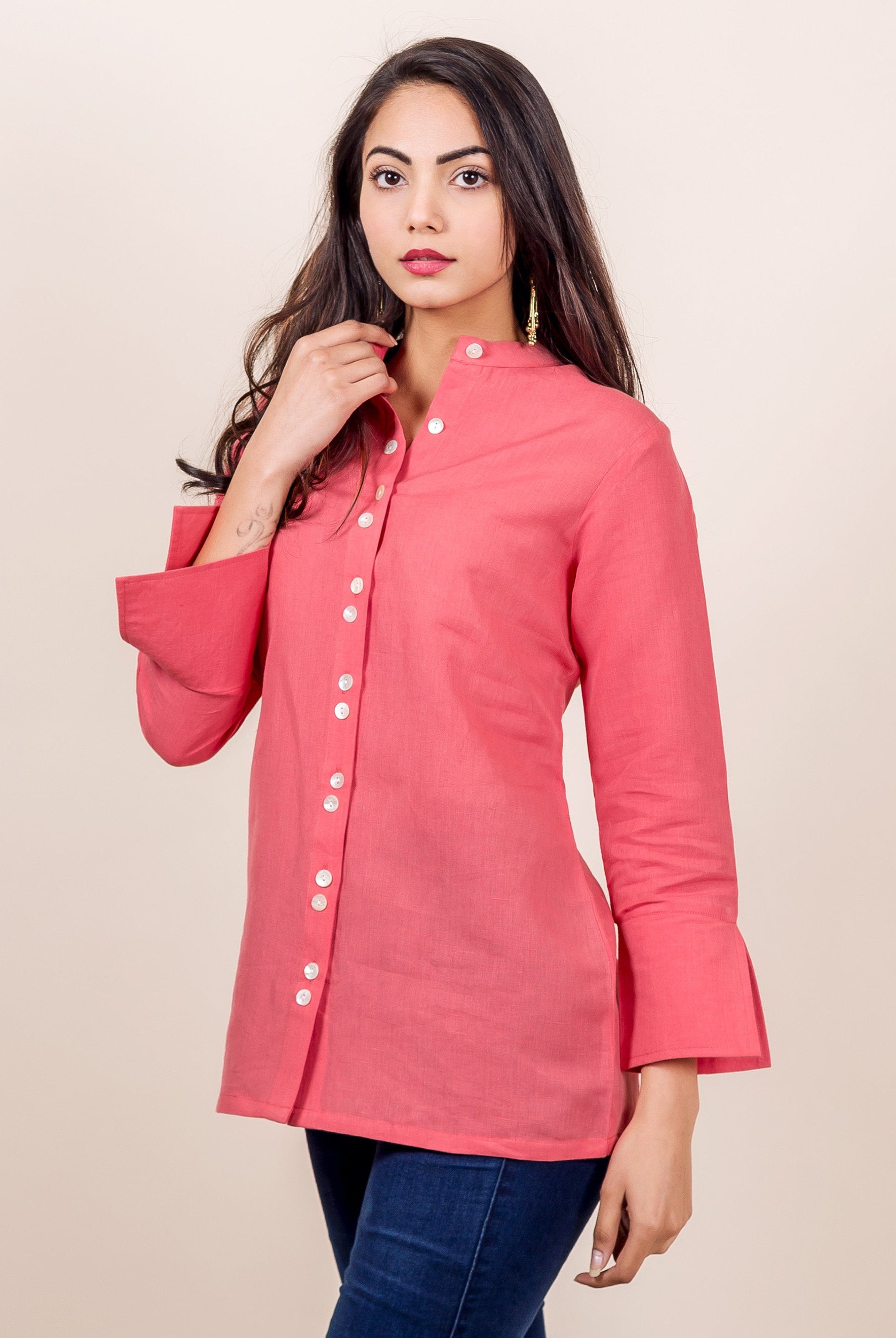 A model wearing a peach linen top with button down placket.