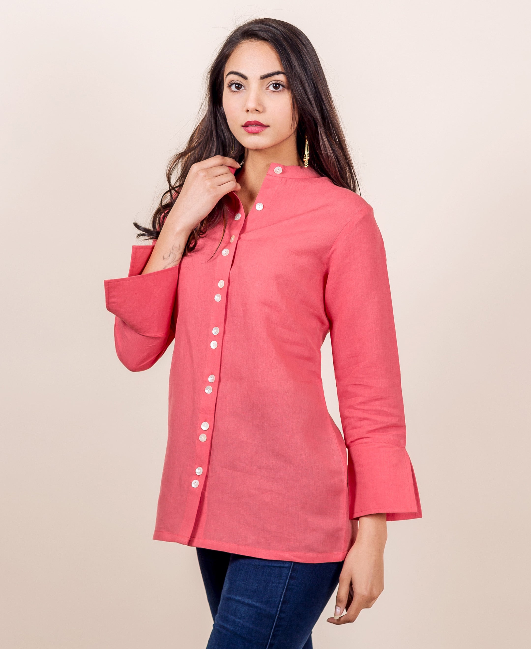A model wearing a peach linen top with button down placket.