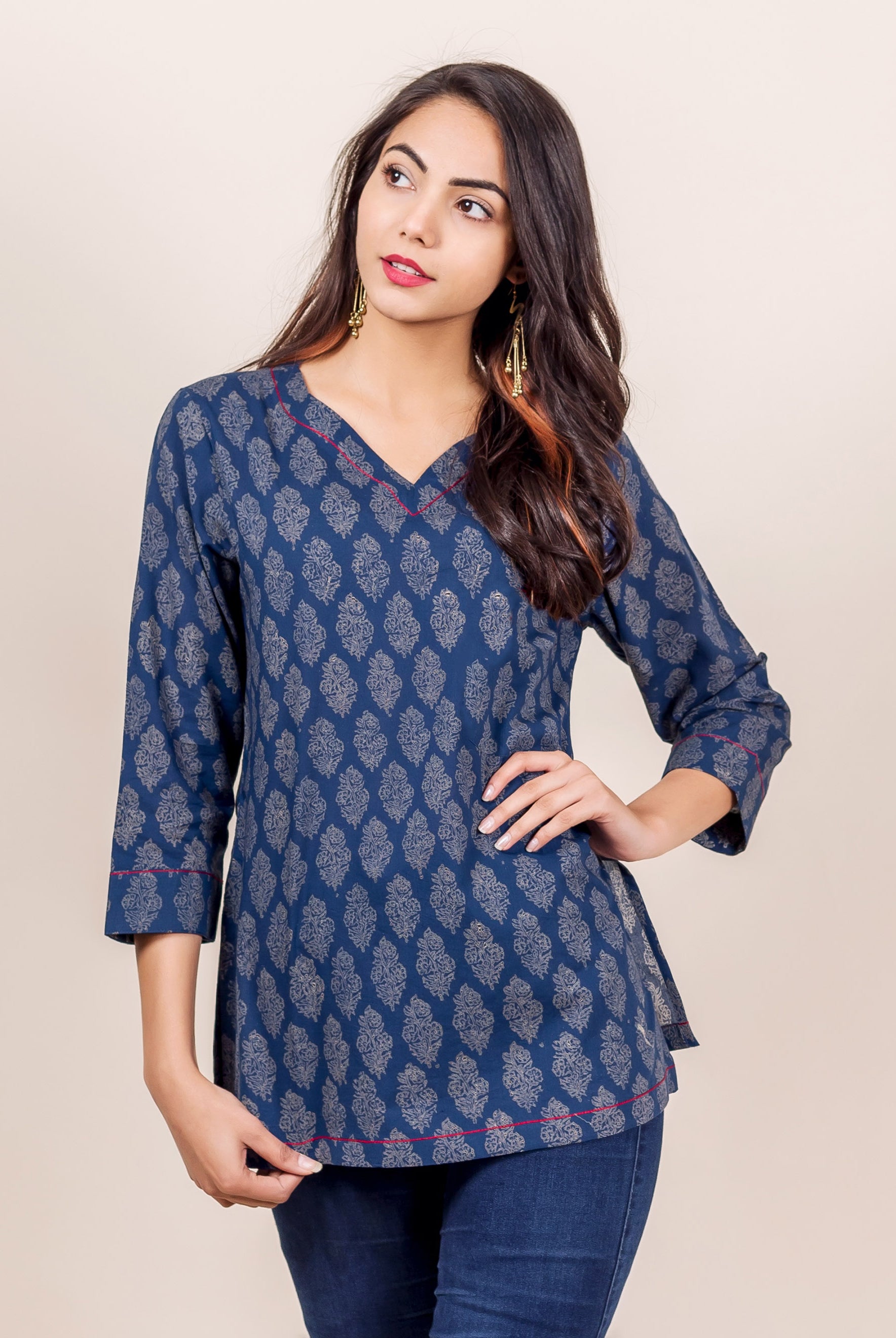 Front view of model wearing an indigo hand block printed top with red piping.