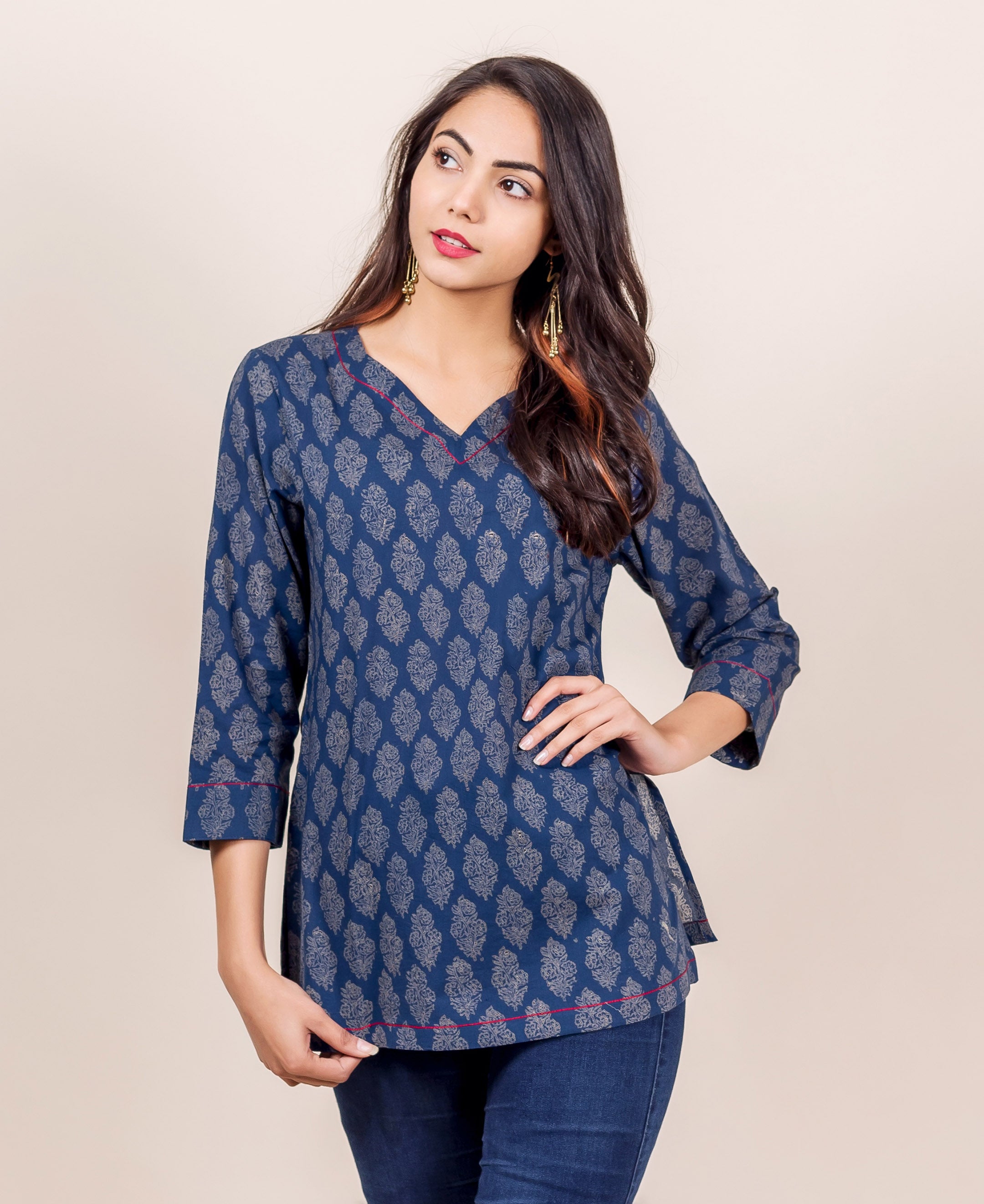 Front view of model wearing an indigo hand block printed top with red piping.