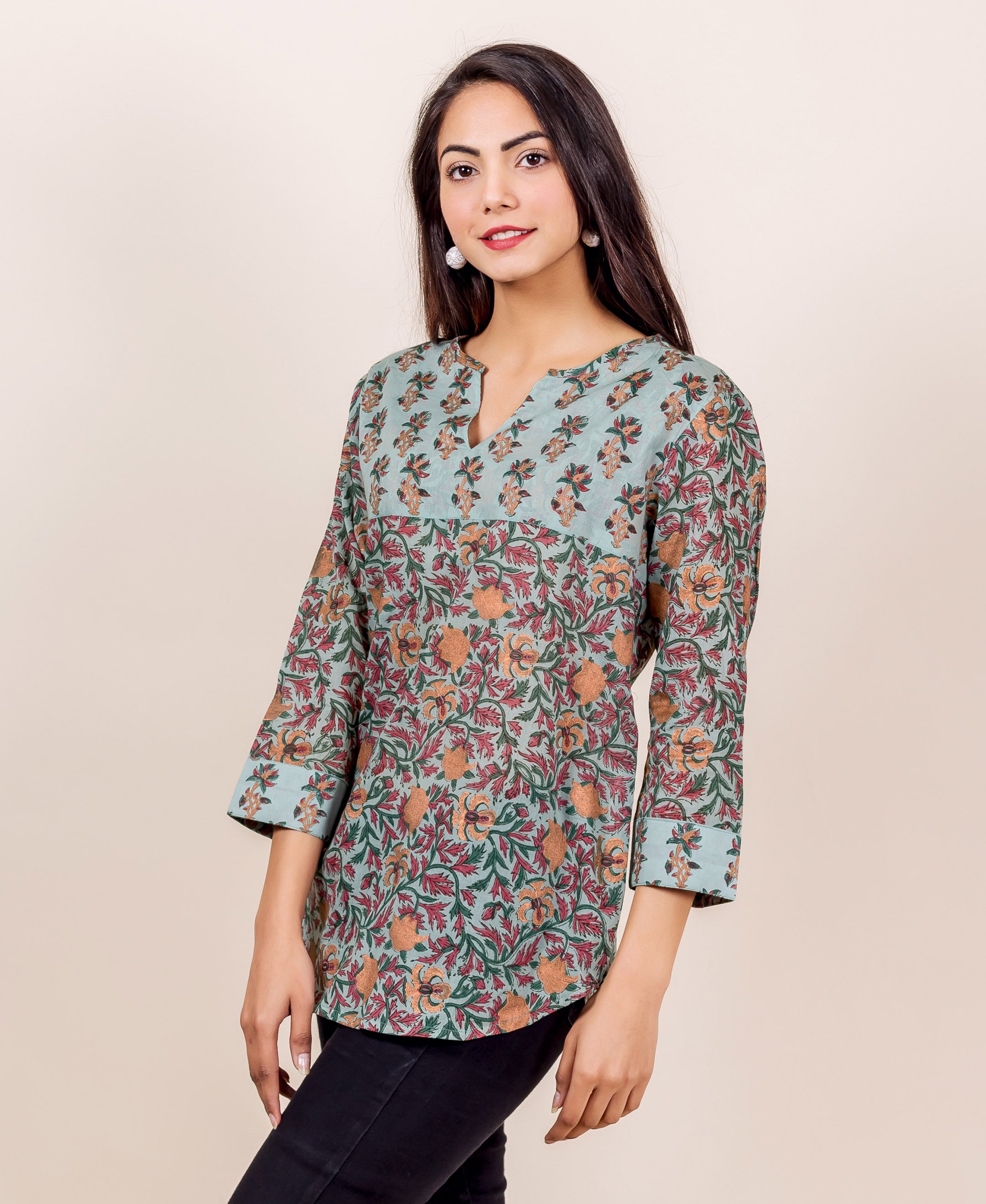 Woman wearing blue, orange, red, and green floral hand-block-printed cotton top with 3/4 sleeves.