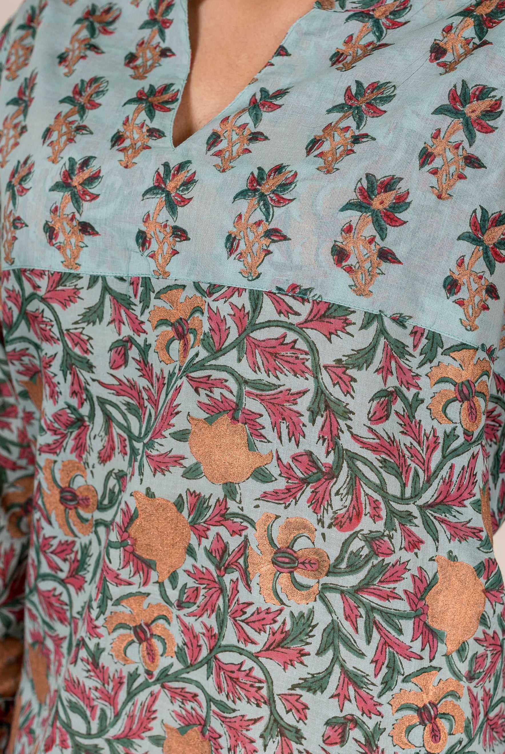 Close-up Turkish blue hand-block printed top, two floral patterns in red, green, and gold.