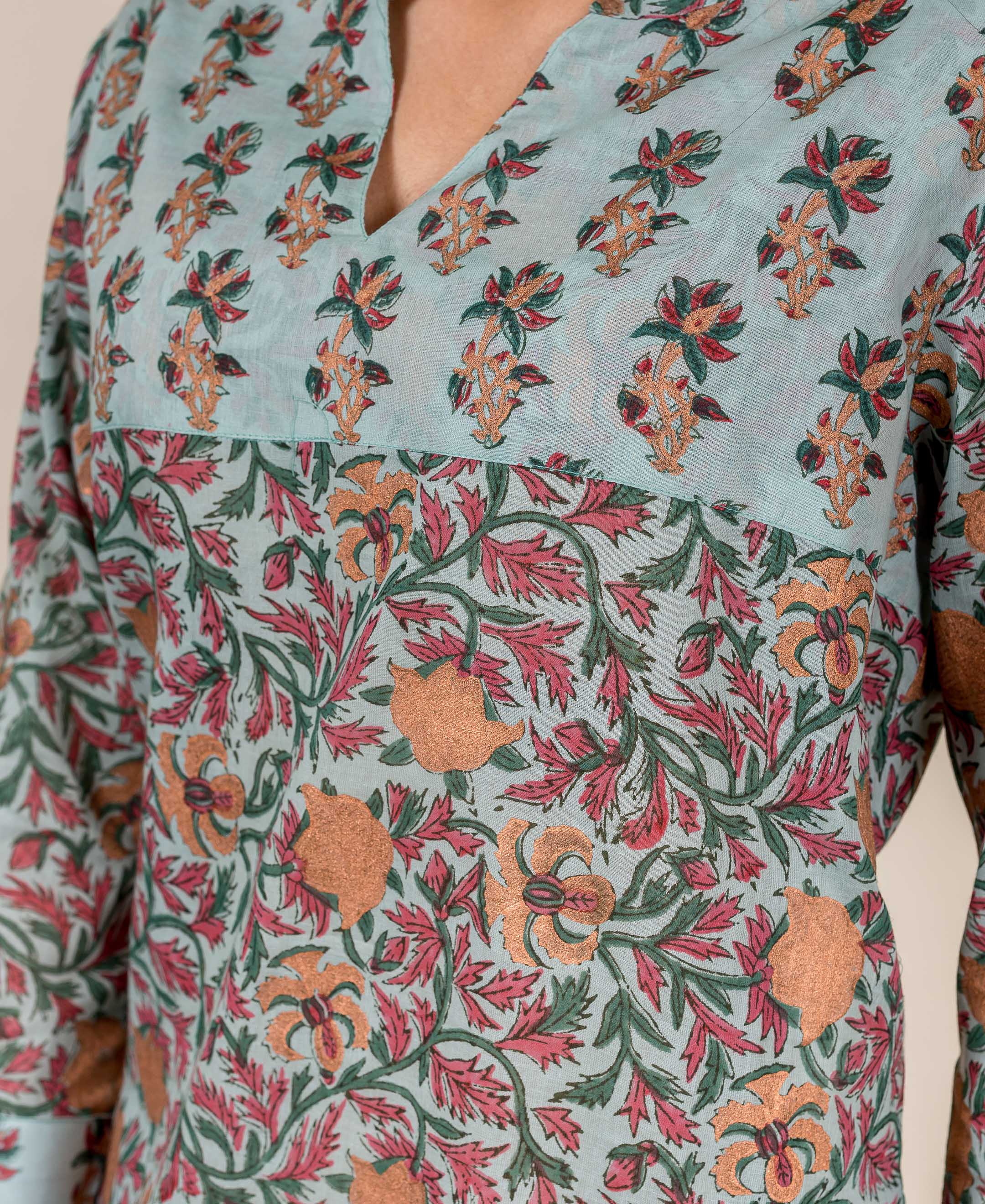 Close-up Turkish blue hand-block printed top, two floral patterns in red, green, and gold.
