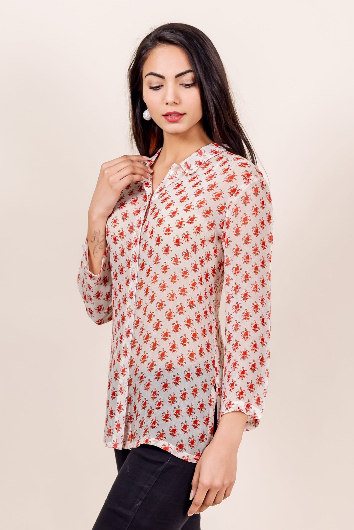 Model wears white georgette shirt with all-over red floral block print, side view.