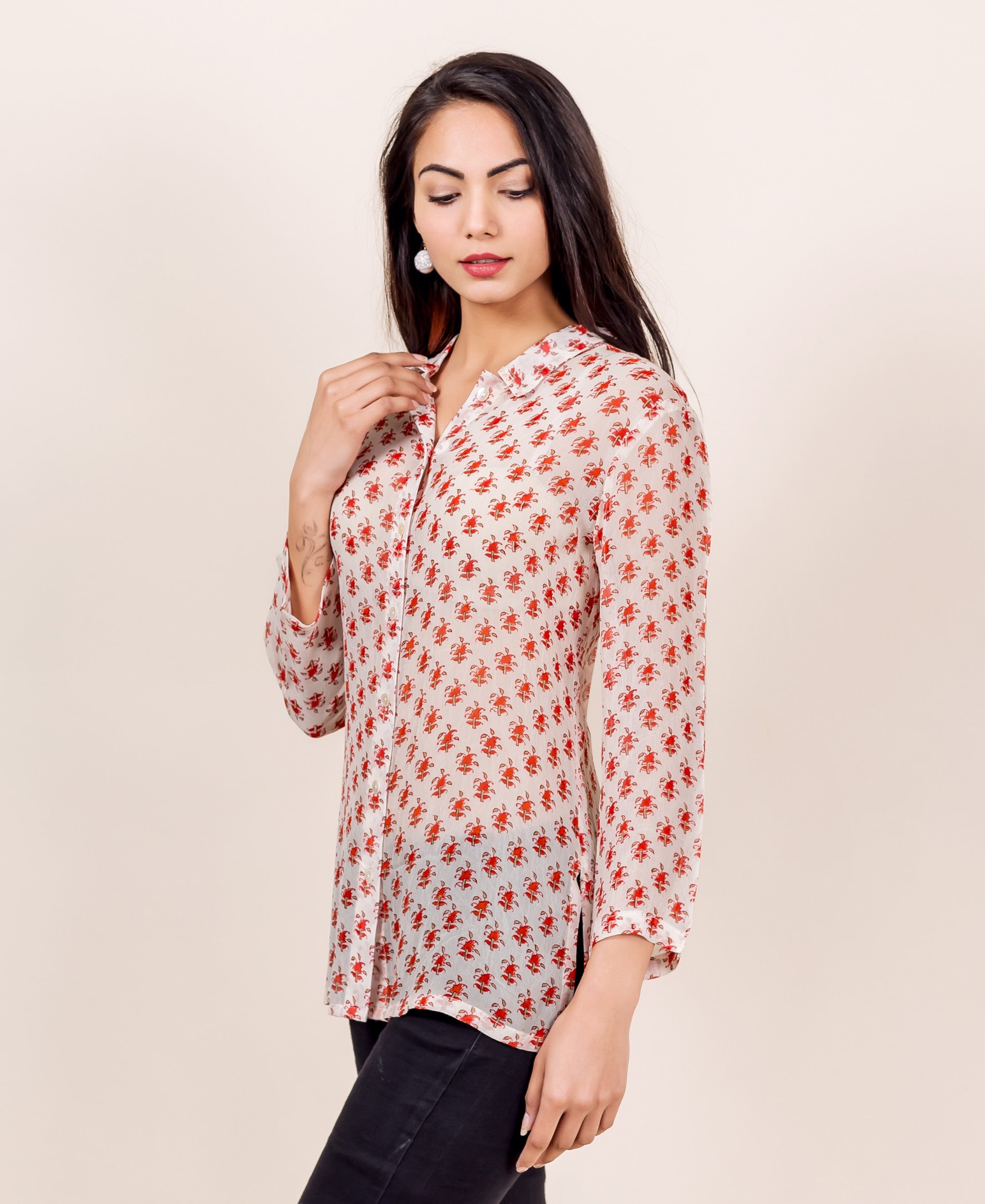 Model wears white georgette shirt with all-over red floral block print, side view.