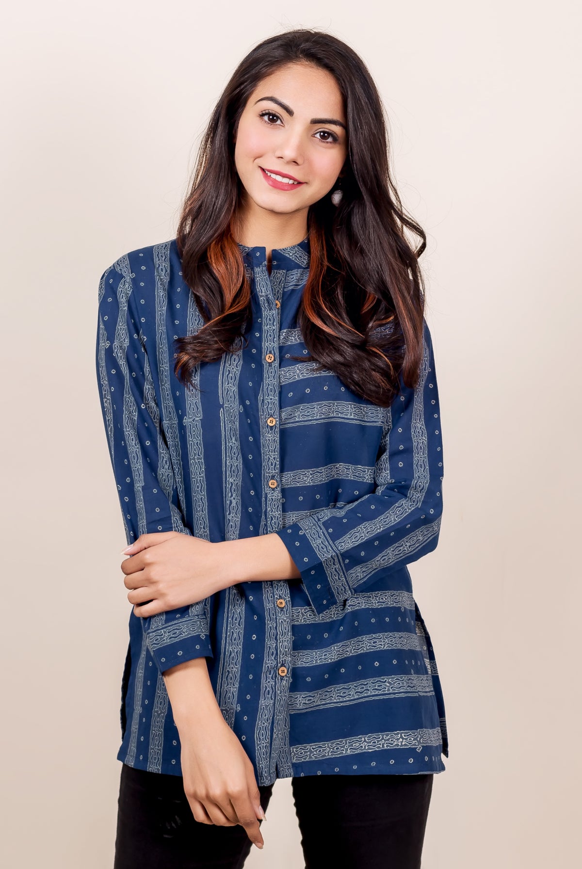 Front view of model wearing an indigo blue block printed button-down shirt with geometric patterns.