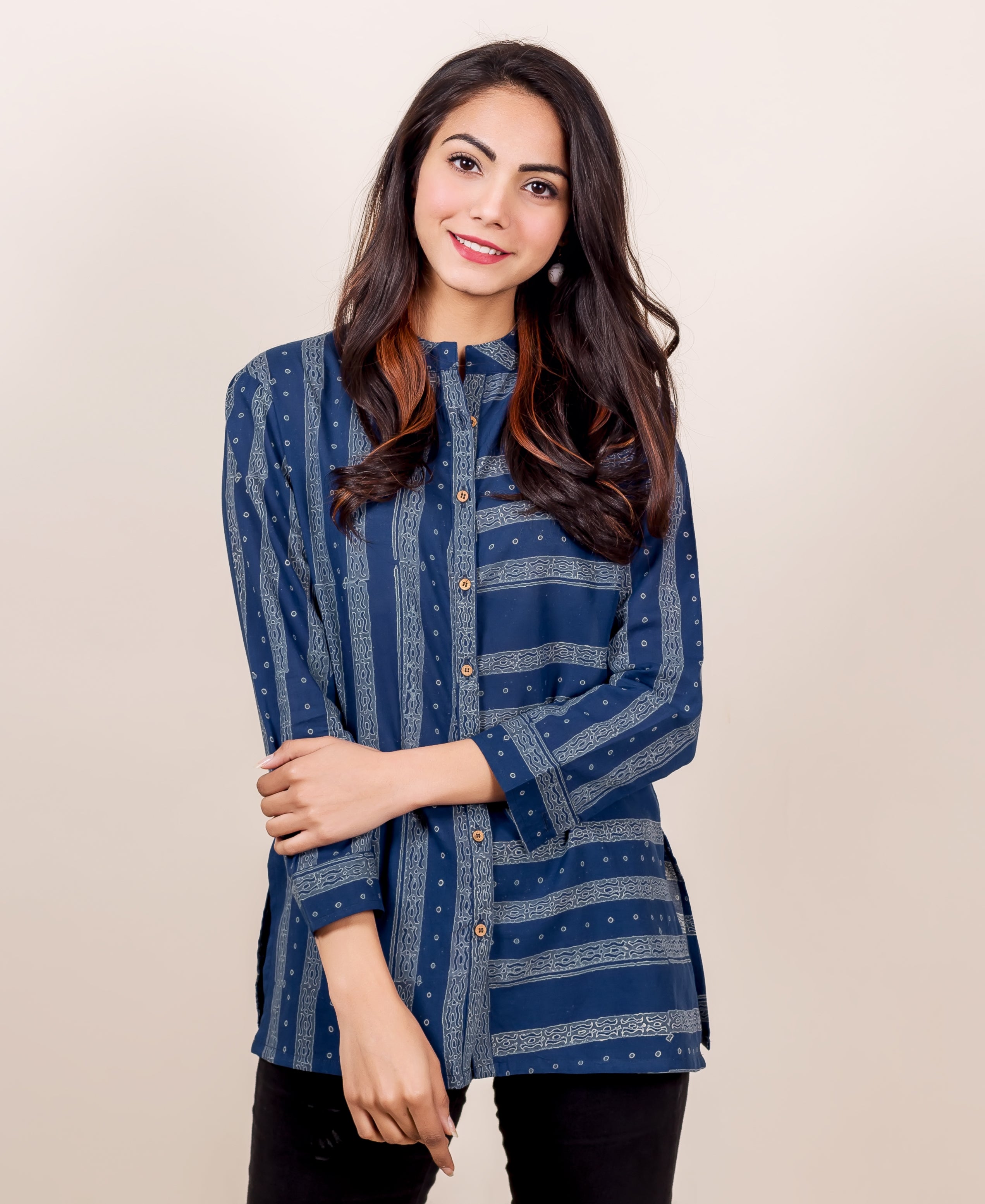 Front view of model wearing an indigo blue block printed button-down shirt with geometric patterns.