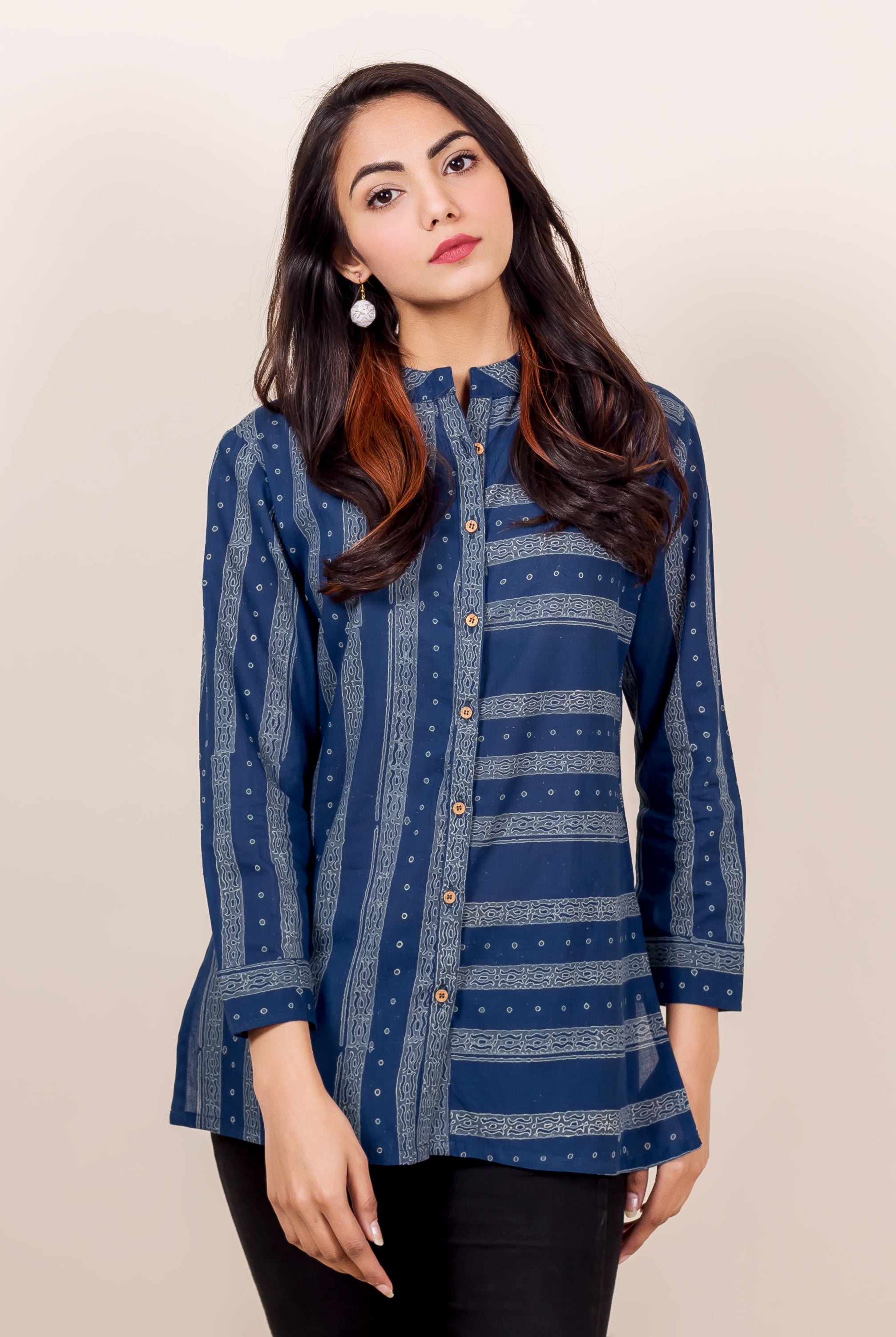 Front of model in indigo block-printed button-down shirt with vertical and horizontal patterns.