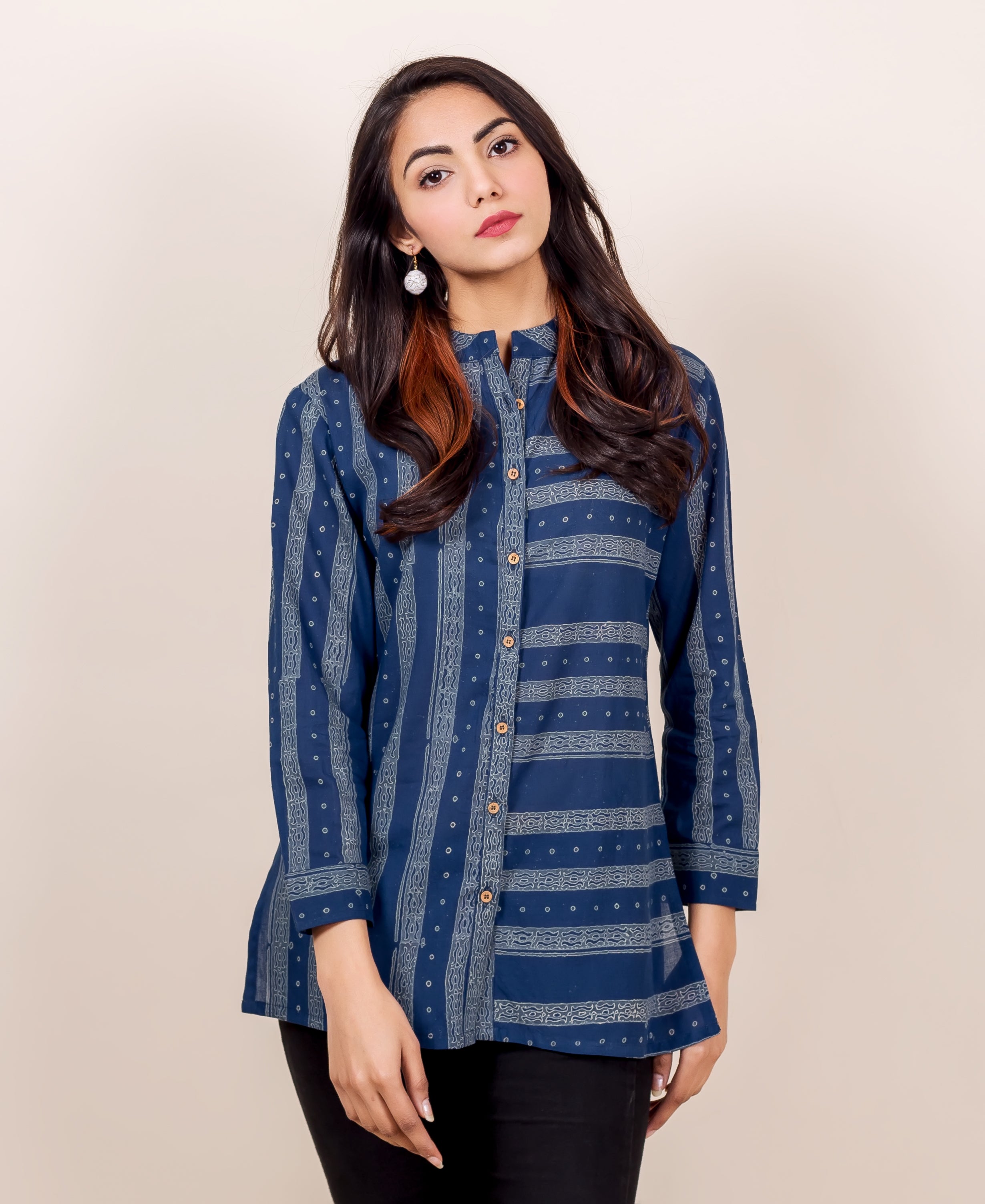 Front of model in indigo block-printed button-down shirt with vertical and horizontal patterns.