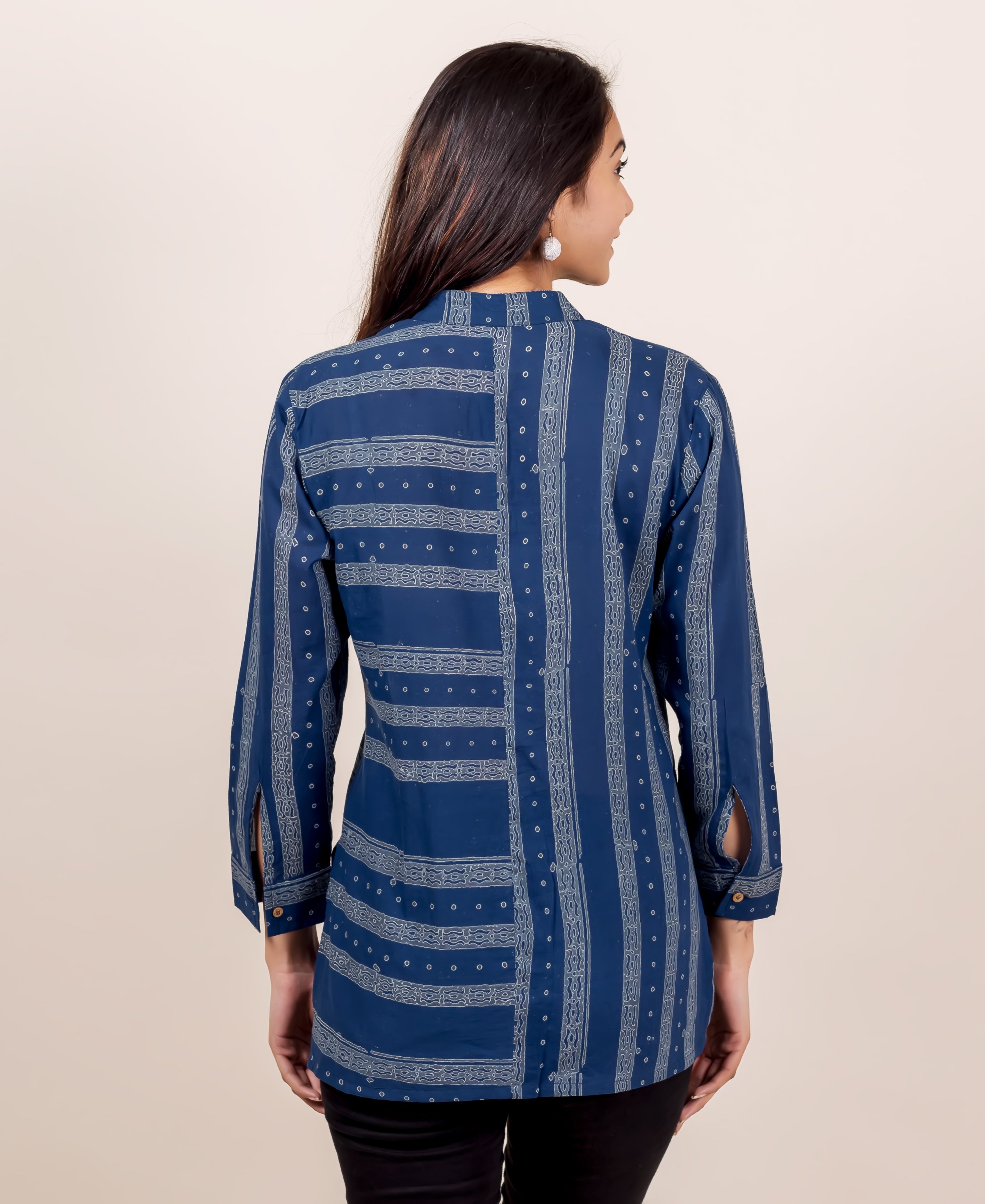 Back view of model in indigo shirt with varied block print patterns and sleeve slits.