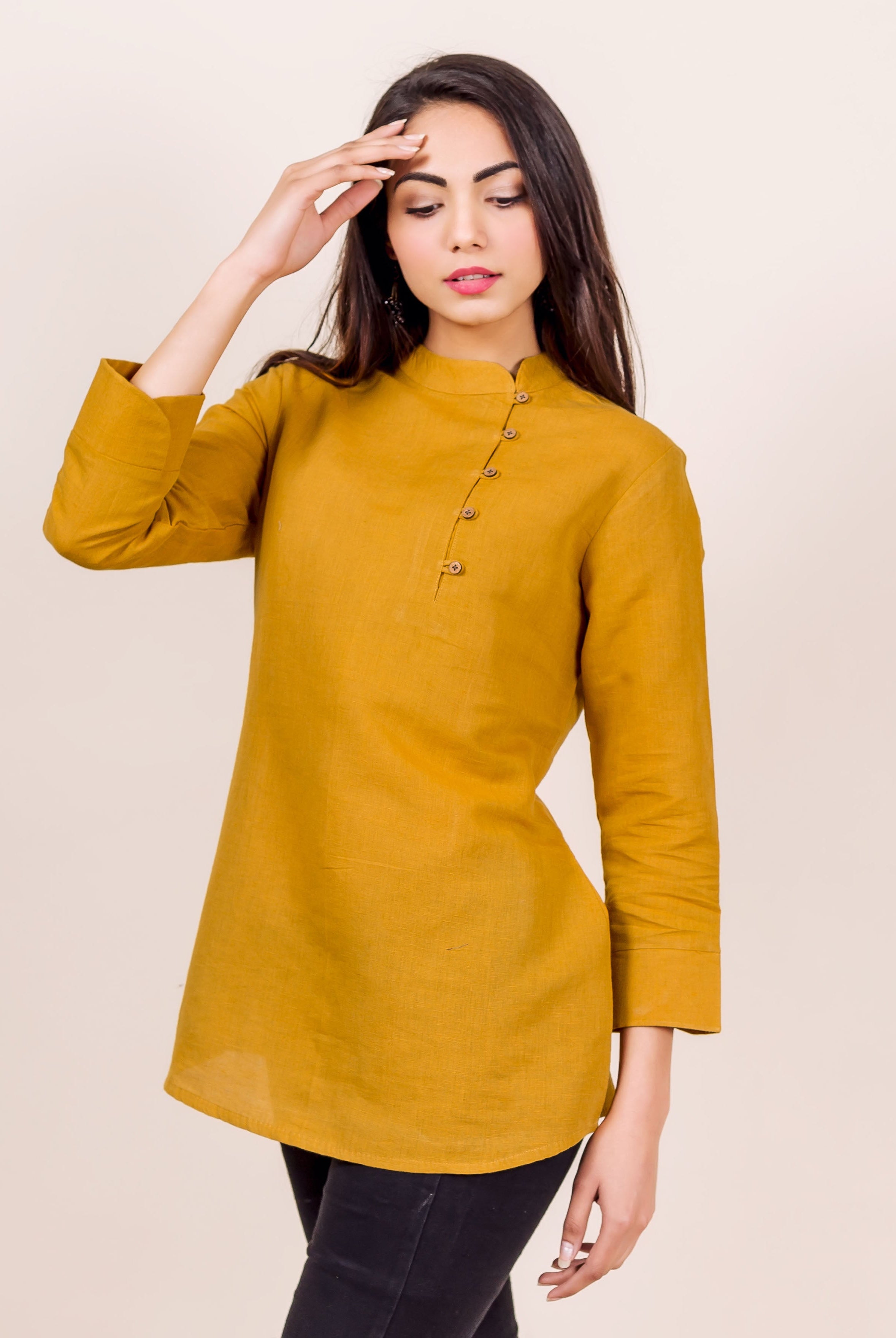 Front view of model wearing a mustard linen Mandarin collar top with asymmetric buttons.
