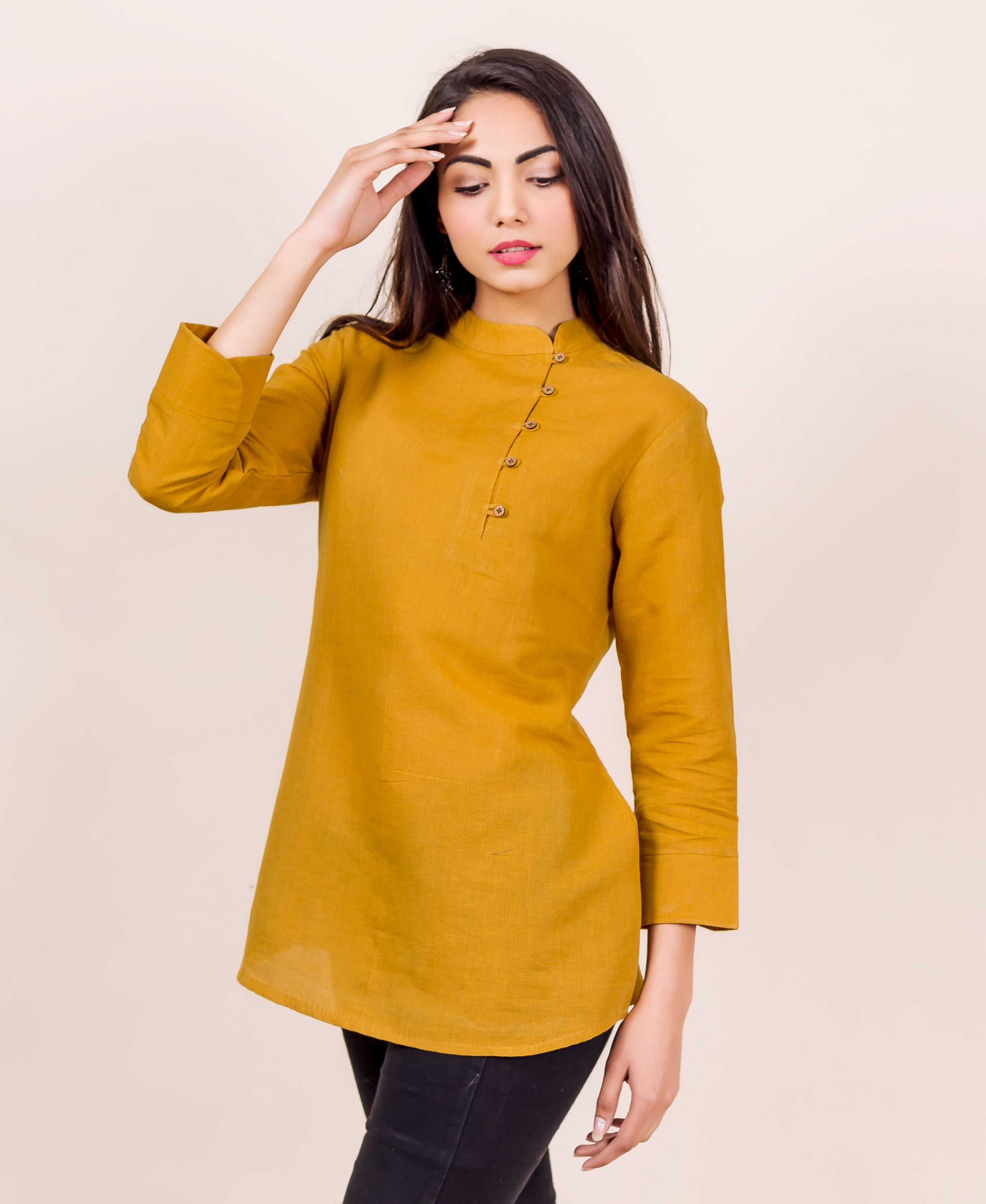 Front view of model wearing a mustard linen Mandarin collar top with asymmetric buttons.