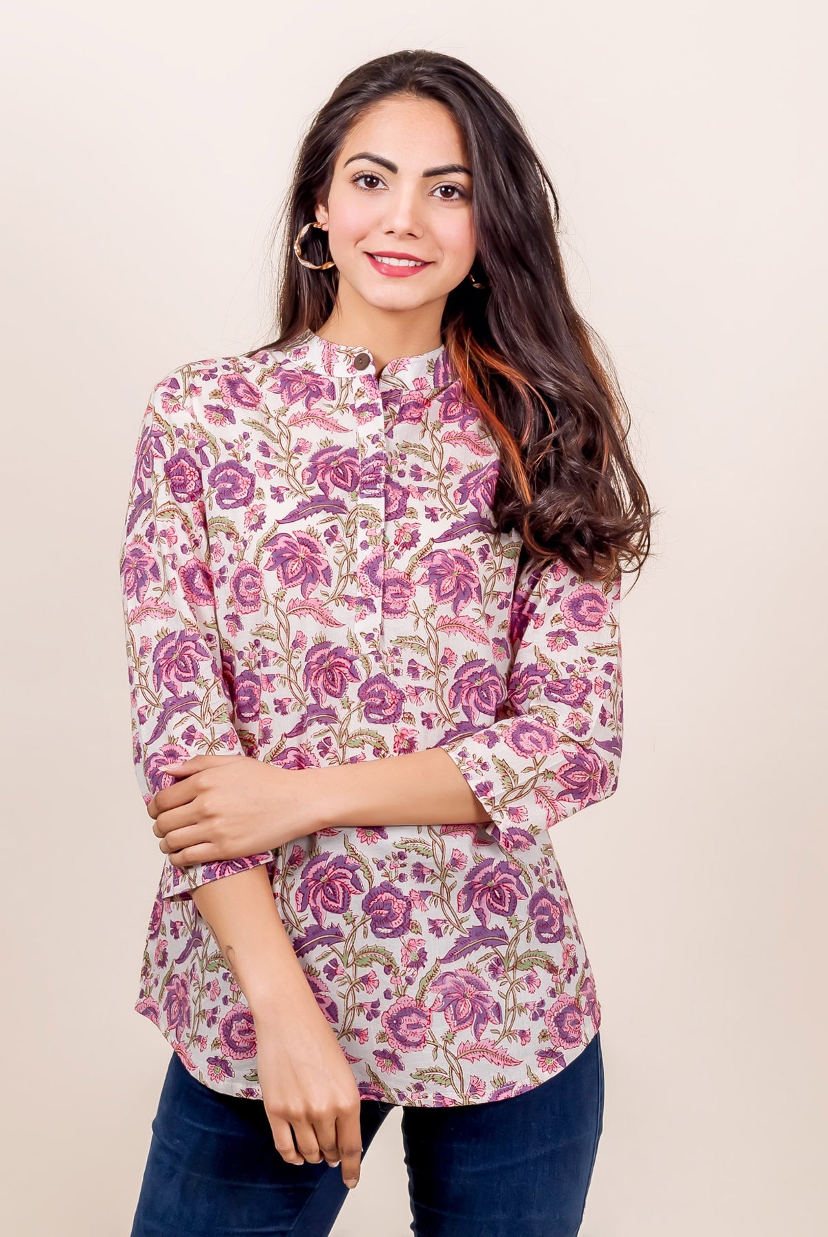 Woman wearing pink and purple floral hand-block-printed top with 3/4 sleeves and high neck.
