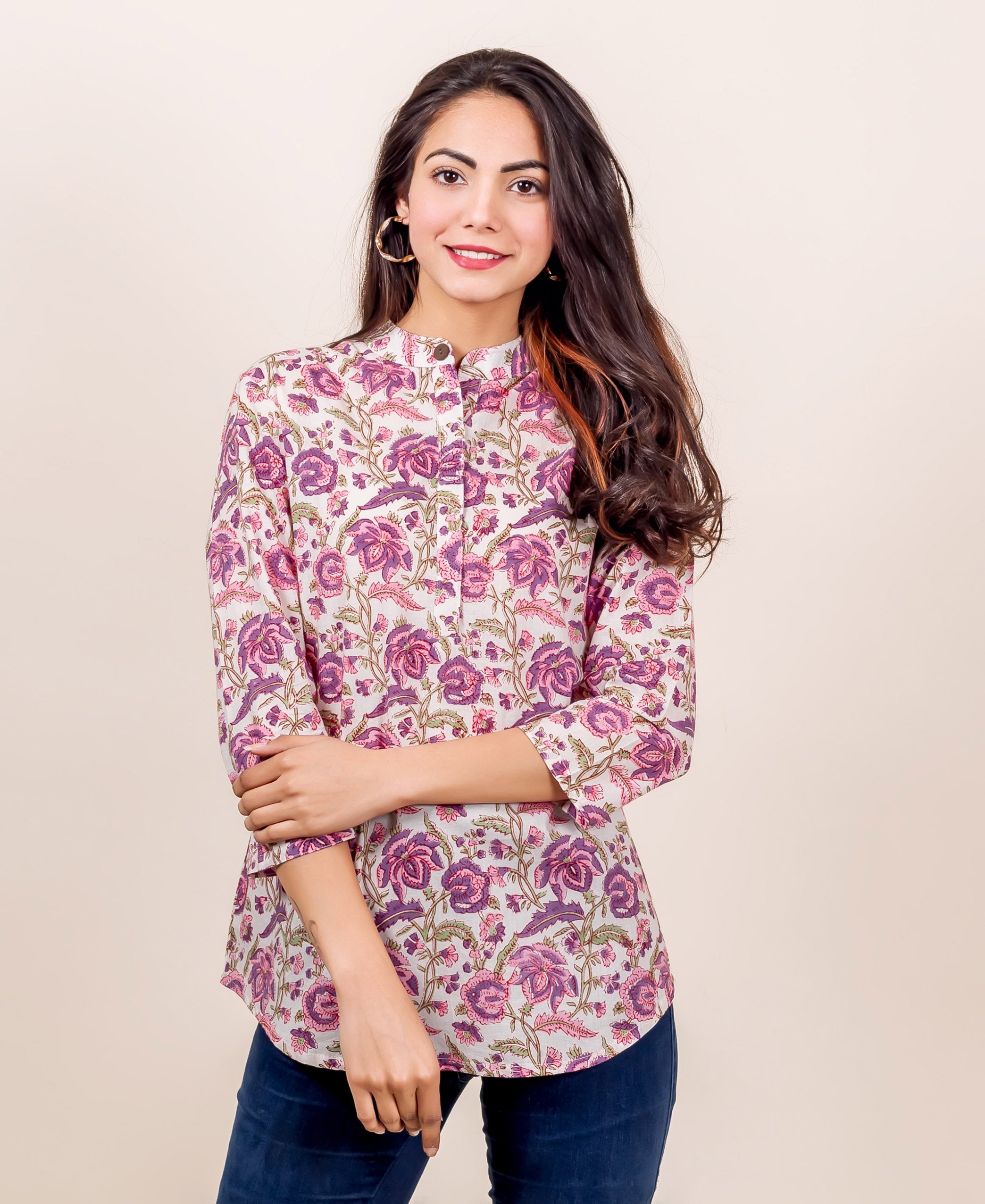 Woman wearing pink and purple floral hand-block-printed top with 3/4 sleeves and high neck.