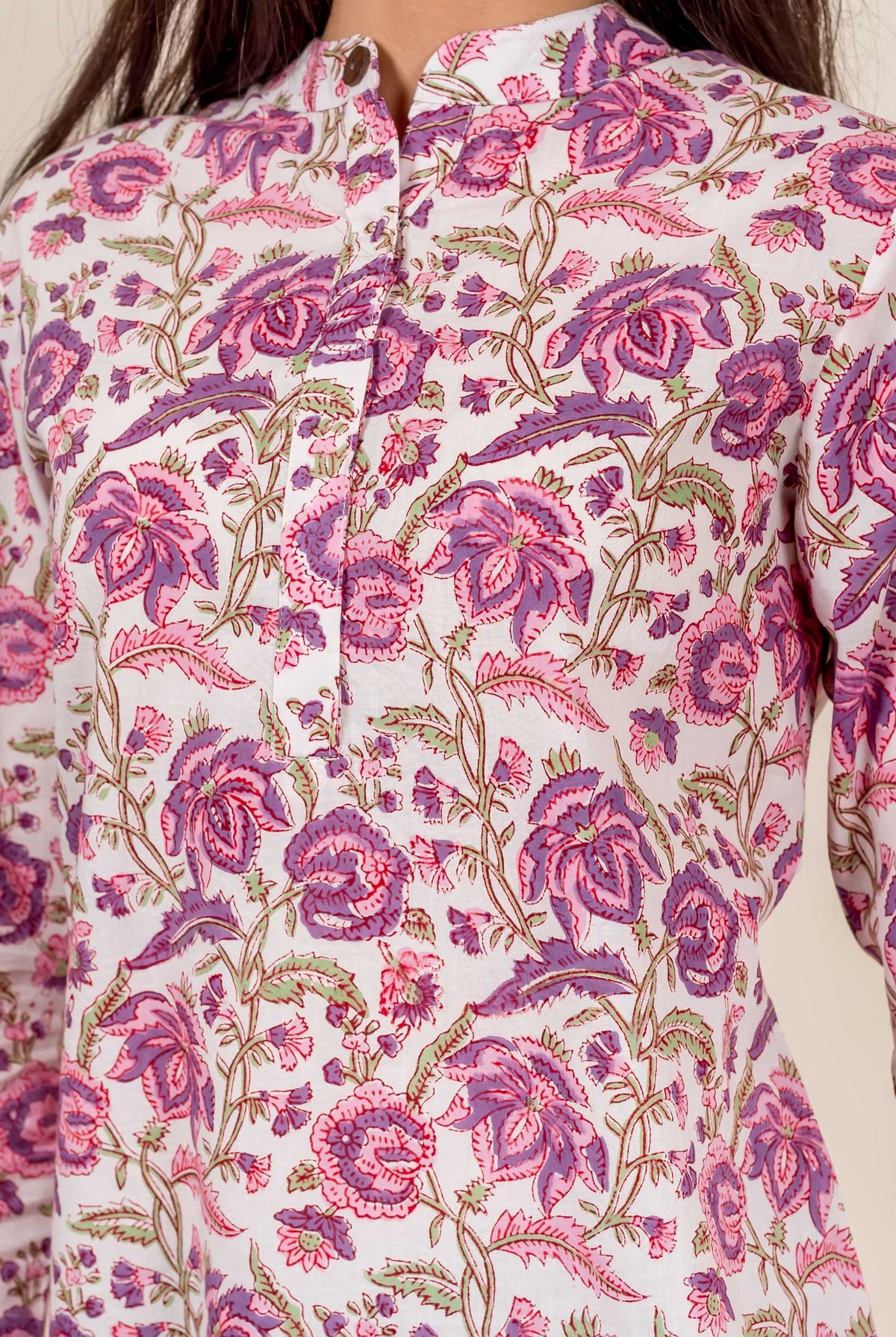 Model wearing a white top with pink and purple floral hand-block print and mandarin collar.