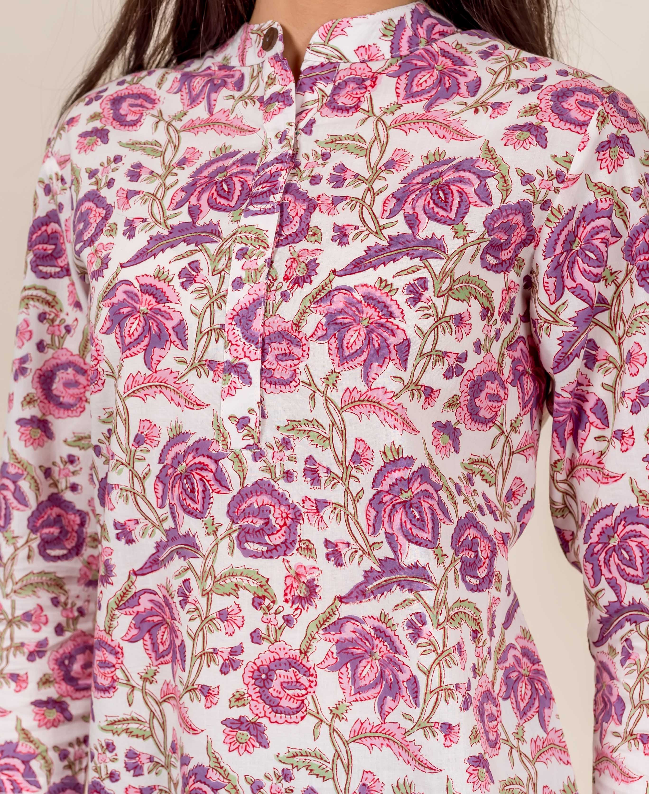 Model wearing a white top with pink and purple floral hand-block print and mandarin collar.