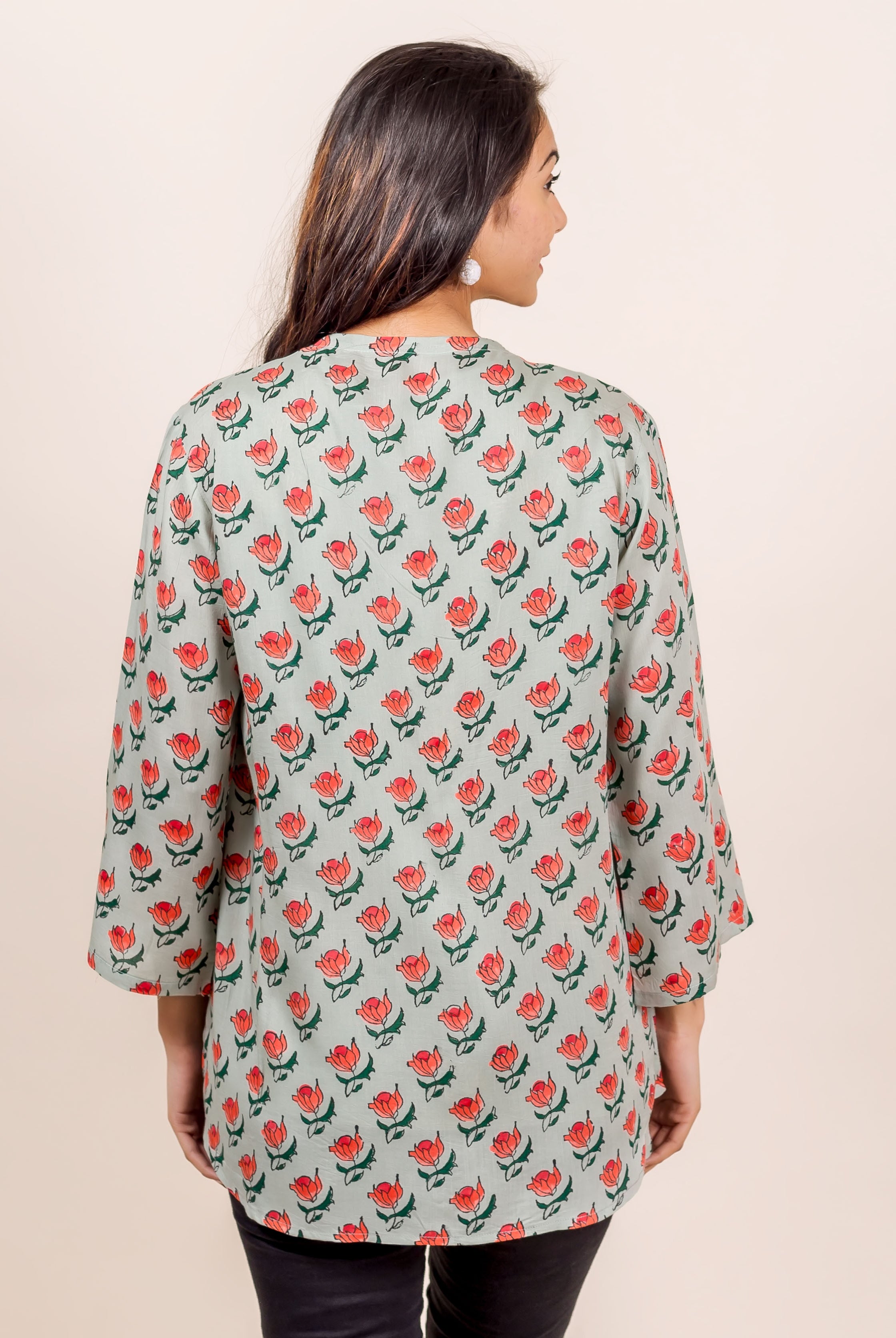 Grey hand block printed shrug top with red floral pattern on a model.
