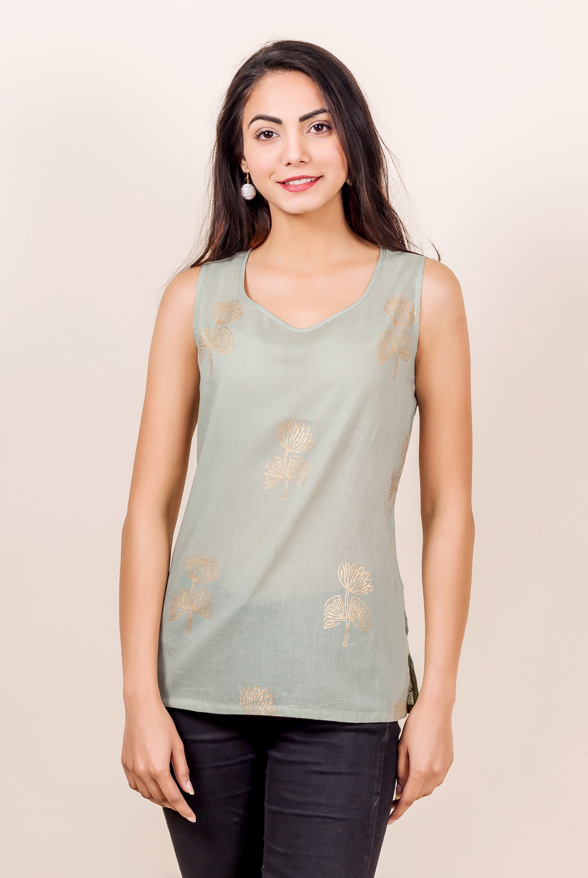 Front model wearing a light grey sleeveless top with golden hand block printed leaves.