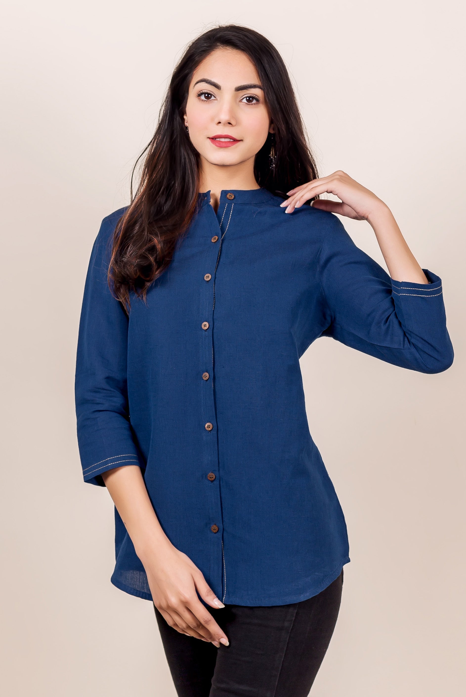 Front view of a model in an indigo linen button-down shirt with contrast stitching.