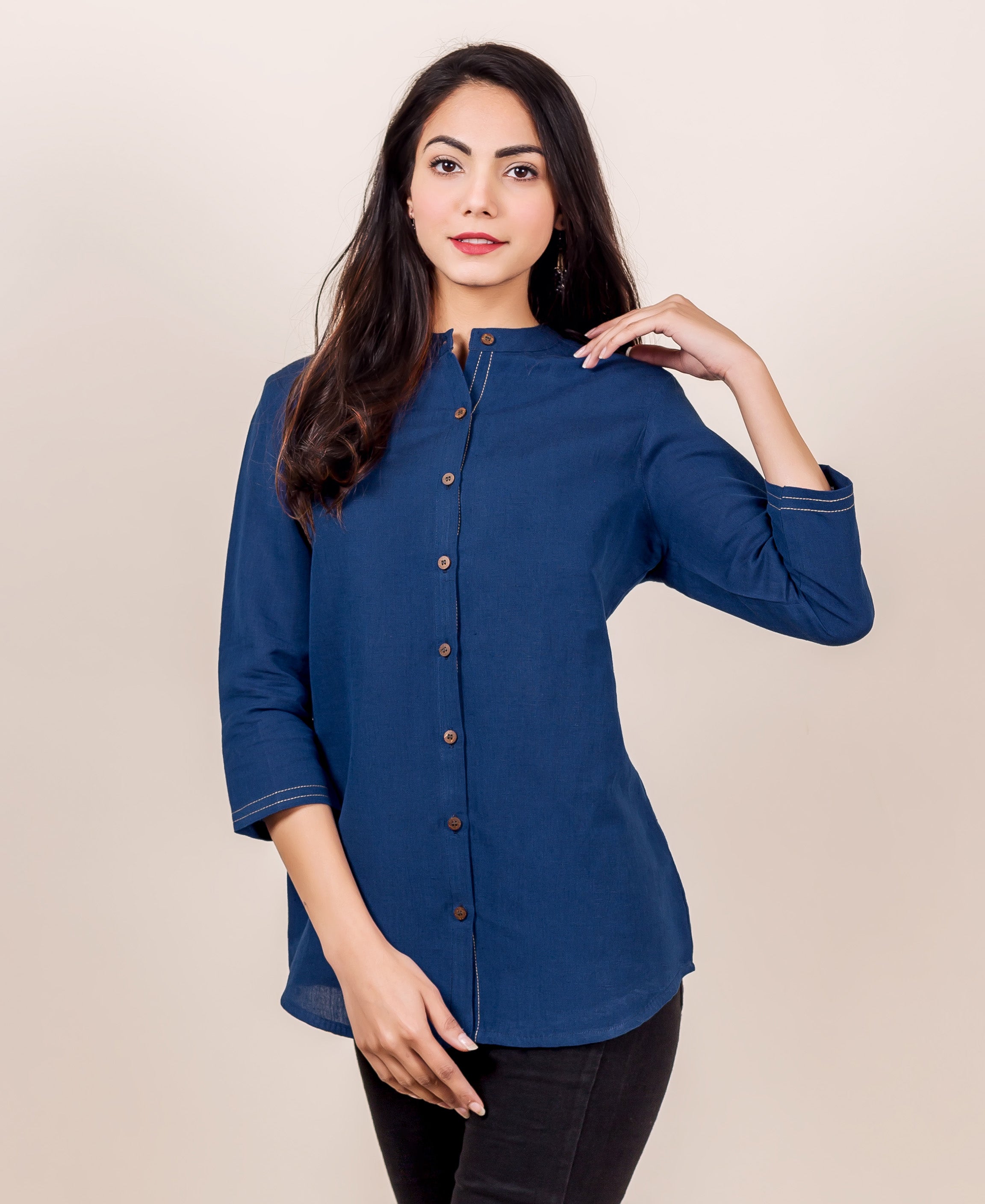 Front view of a model in an indigo linen button-down shirt with contrast stitching.
