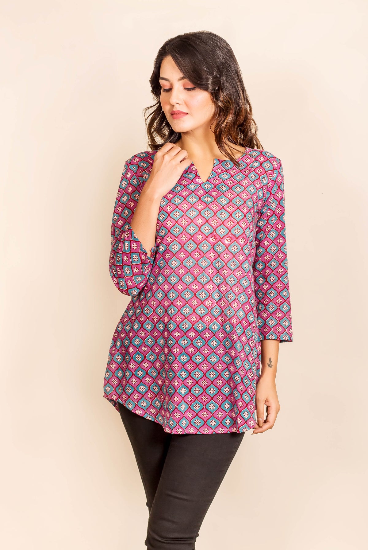 Model wearing a purple and blue geometric print three-quarter sleeve tunic top.