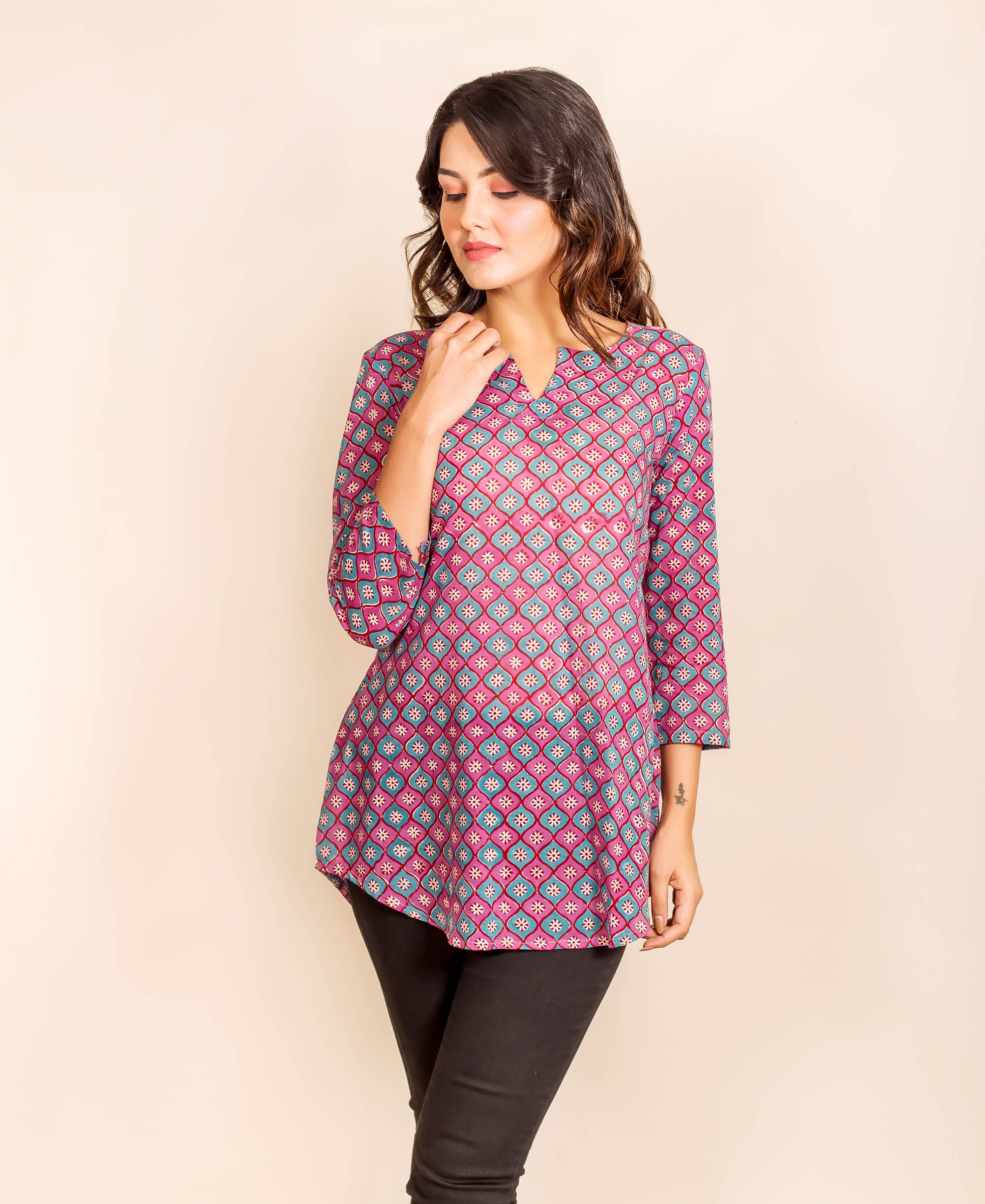 Model wearing a purple and blue geometric print three-quarter sleeve tunic top.