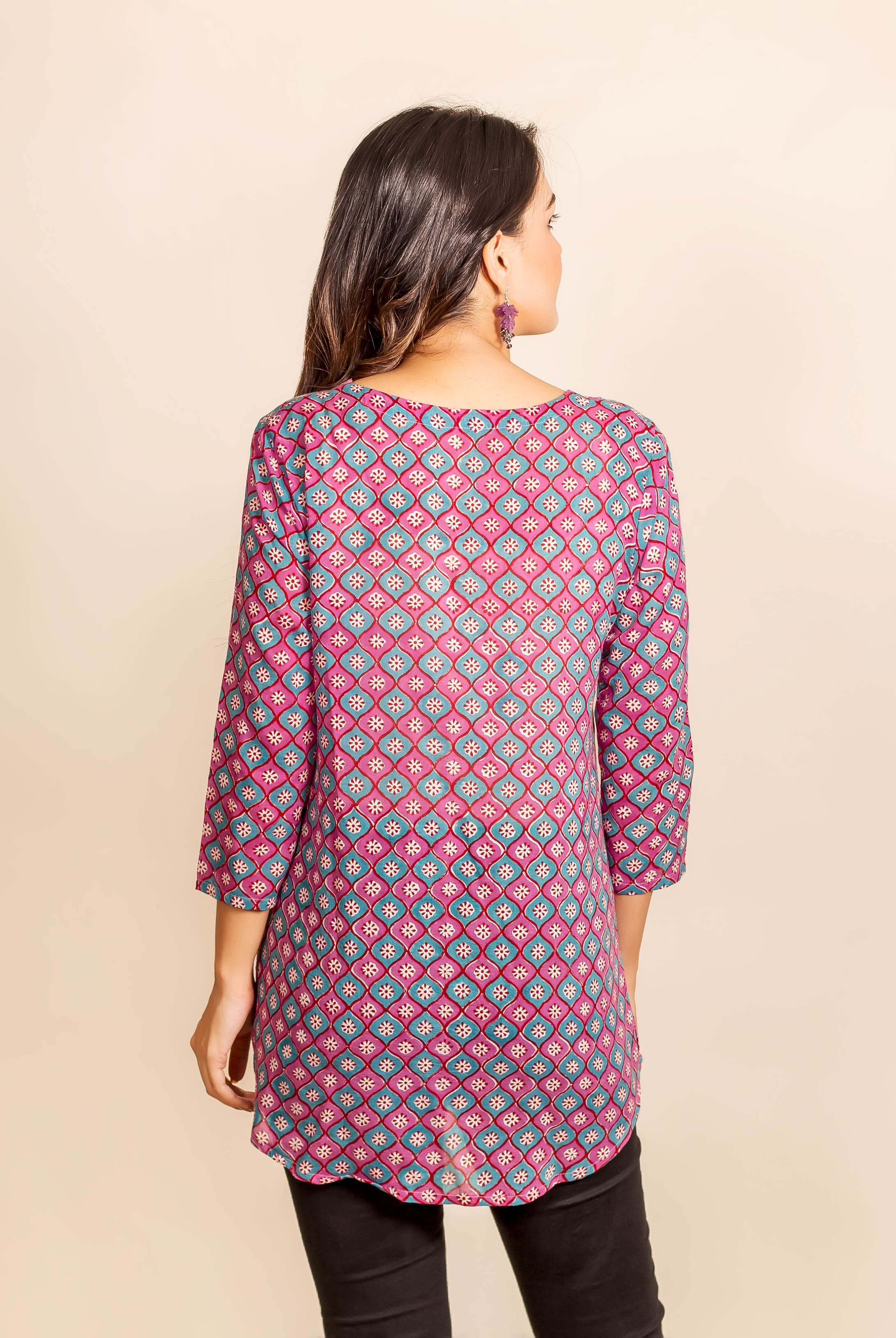 Back view of a model wearing a pink and blue geometric hand-block-printed tunic.