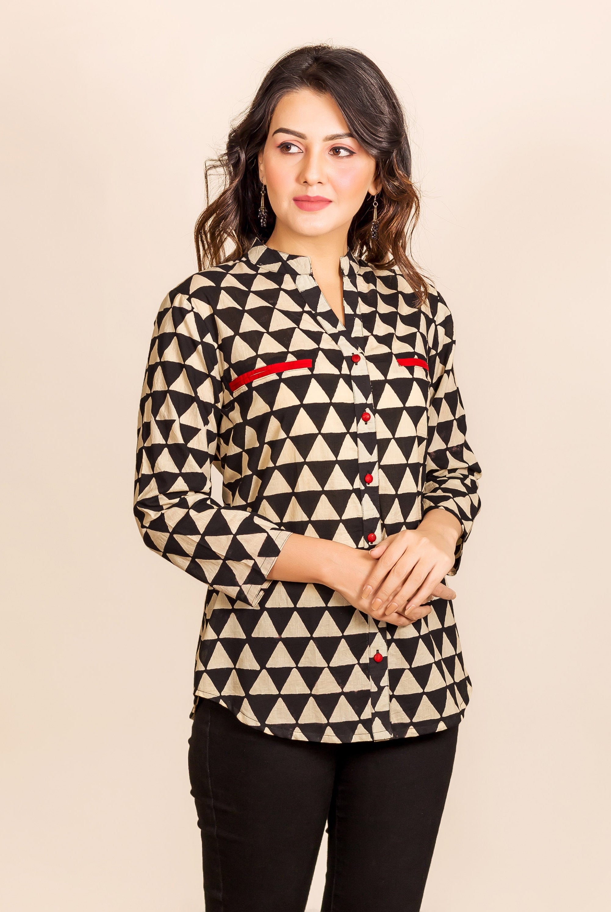 Model wearing a black and beige triangle print shirt-style top with red accents.